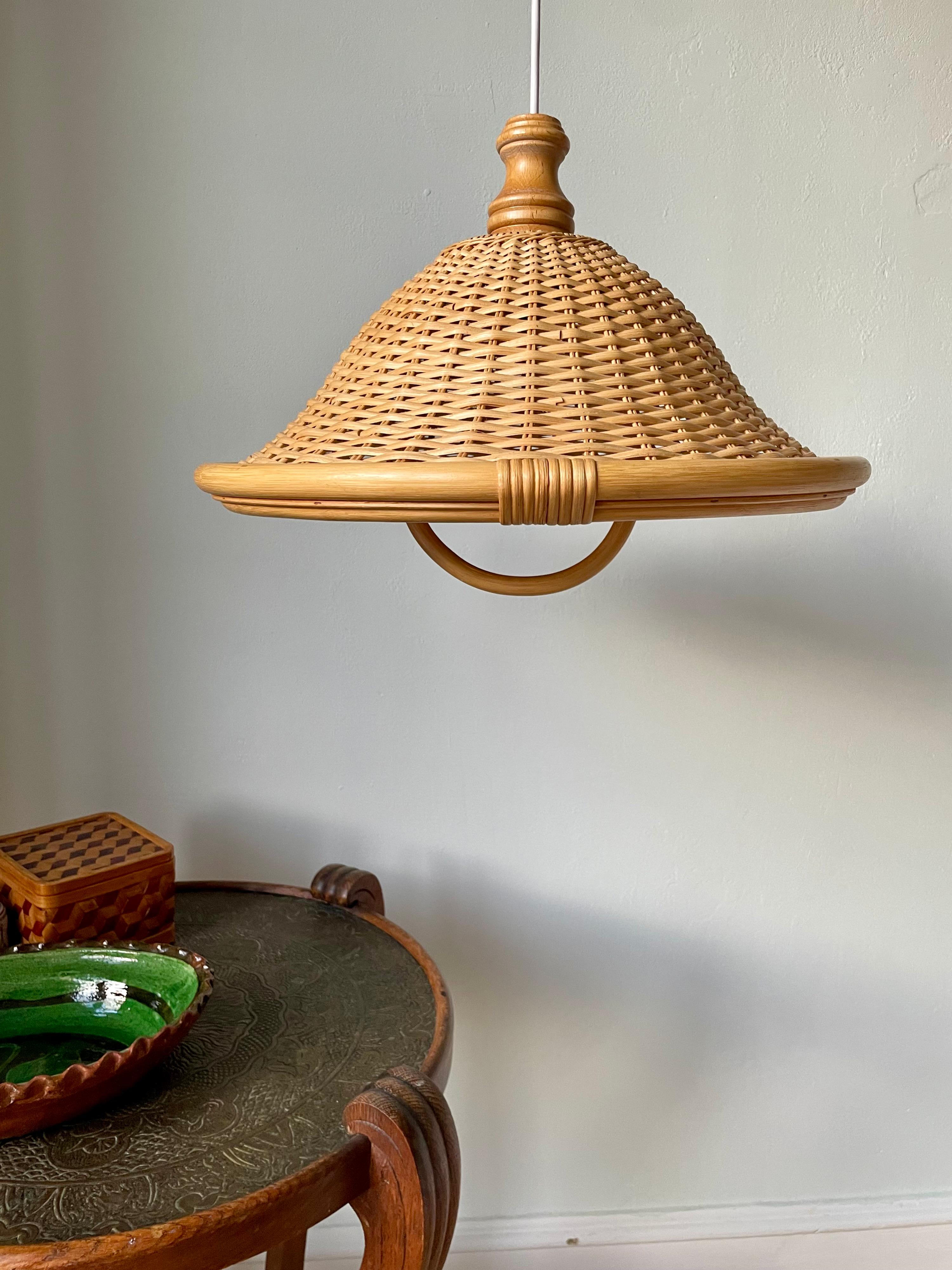 Scandinavian organic modern braided bamboo pendant with round decorative handle making it possible to wire it with an elastic suspension cord and use the handle to pull it up and down. Loosely placed pine wood top and round bamboo edges. Rewired and