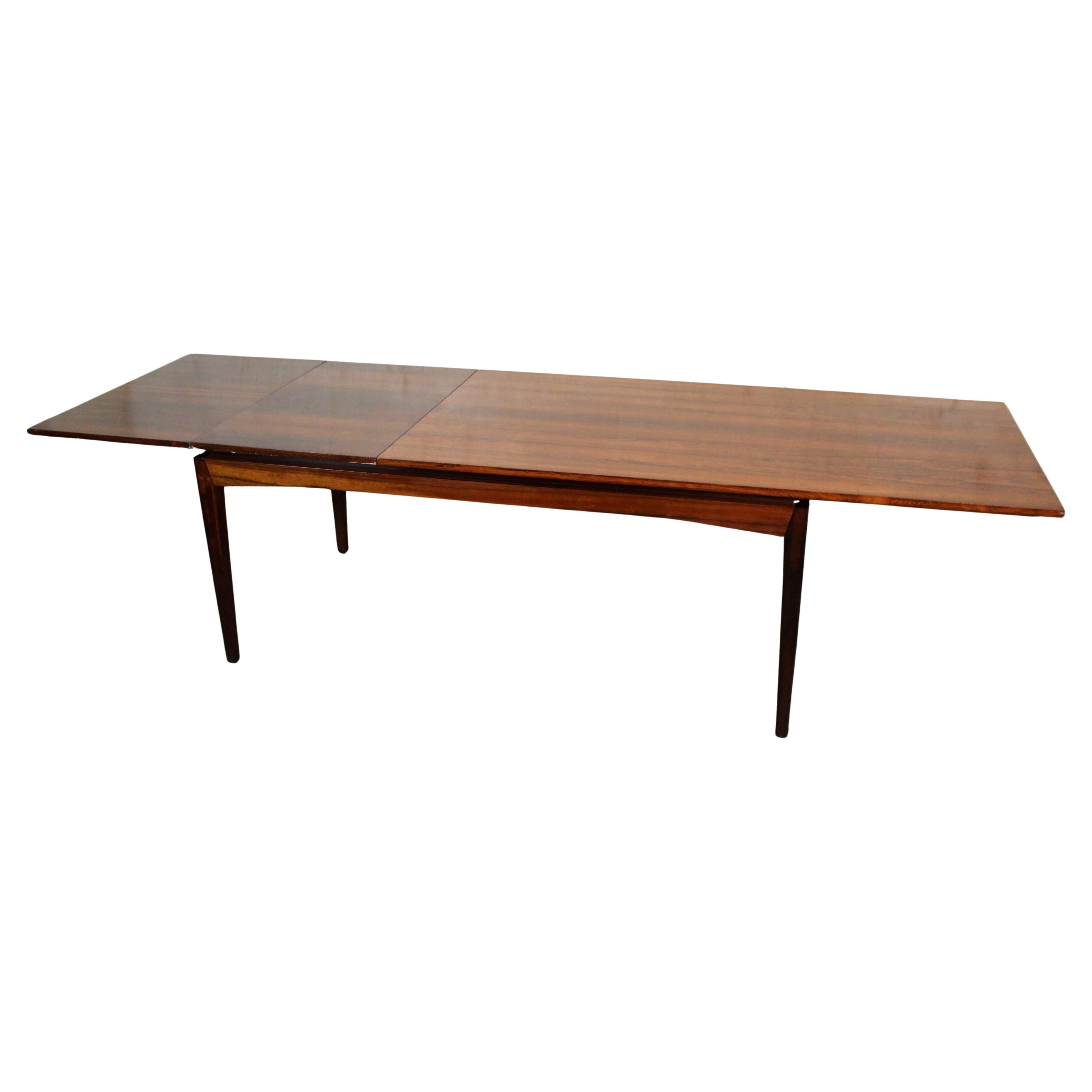 Elegante, escultural y sumamente funcional, esta mesa vintage Bramin Möbler ejemplifica a la perfección la estética moderna danesa. Fabricada en Dinamarca en la década de 1960, la pieza se compone de madera maciza de palisandro -de veteado cálido y