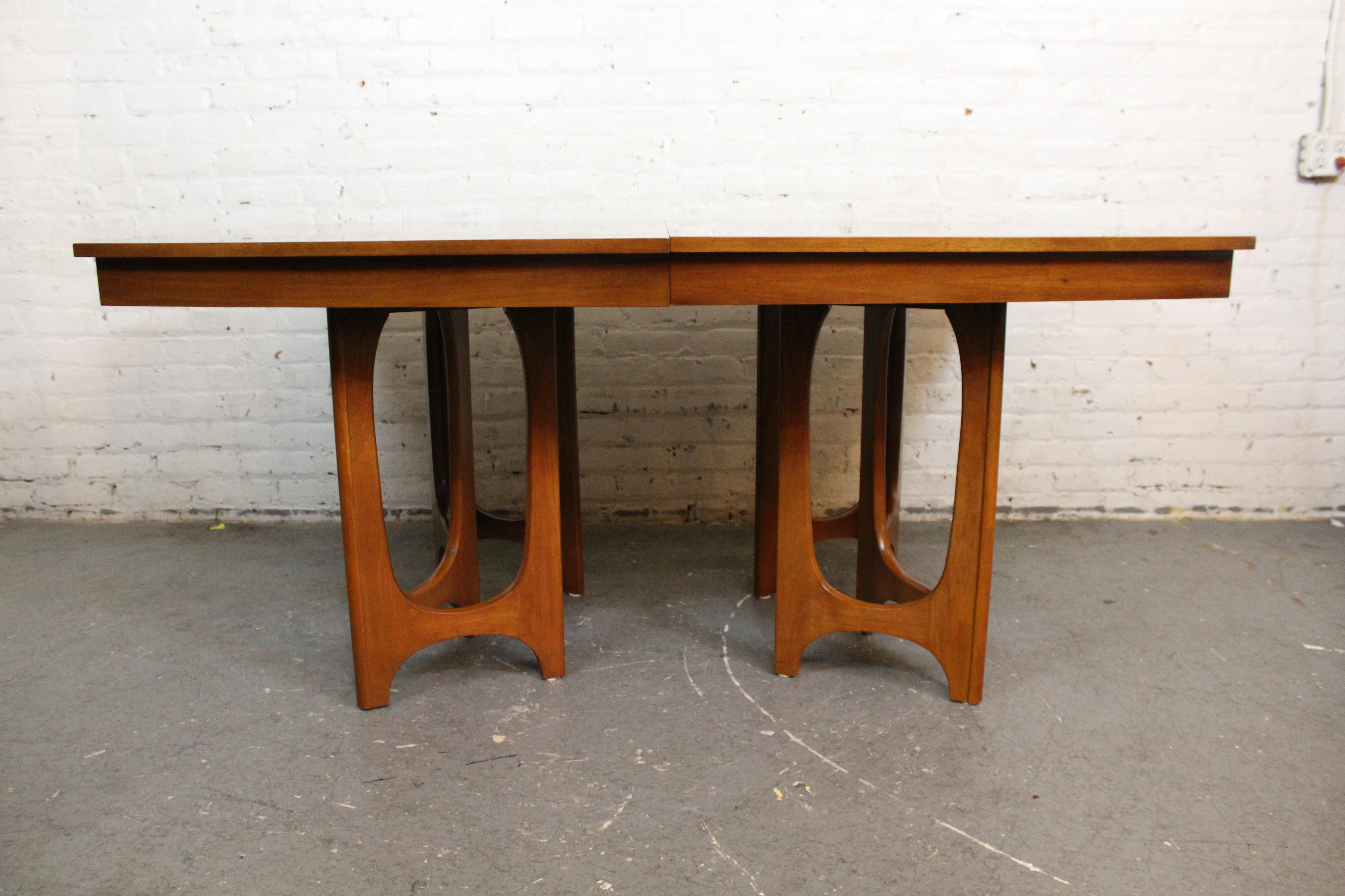 Elevate any dining space with this stunning mid-century vintage extending table built by the skilled craftsmen of Kentucky's Young Manufacturing Company. Taking cues from popular contemporary furniture such as Broyhill's iconic 