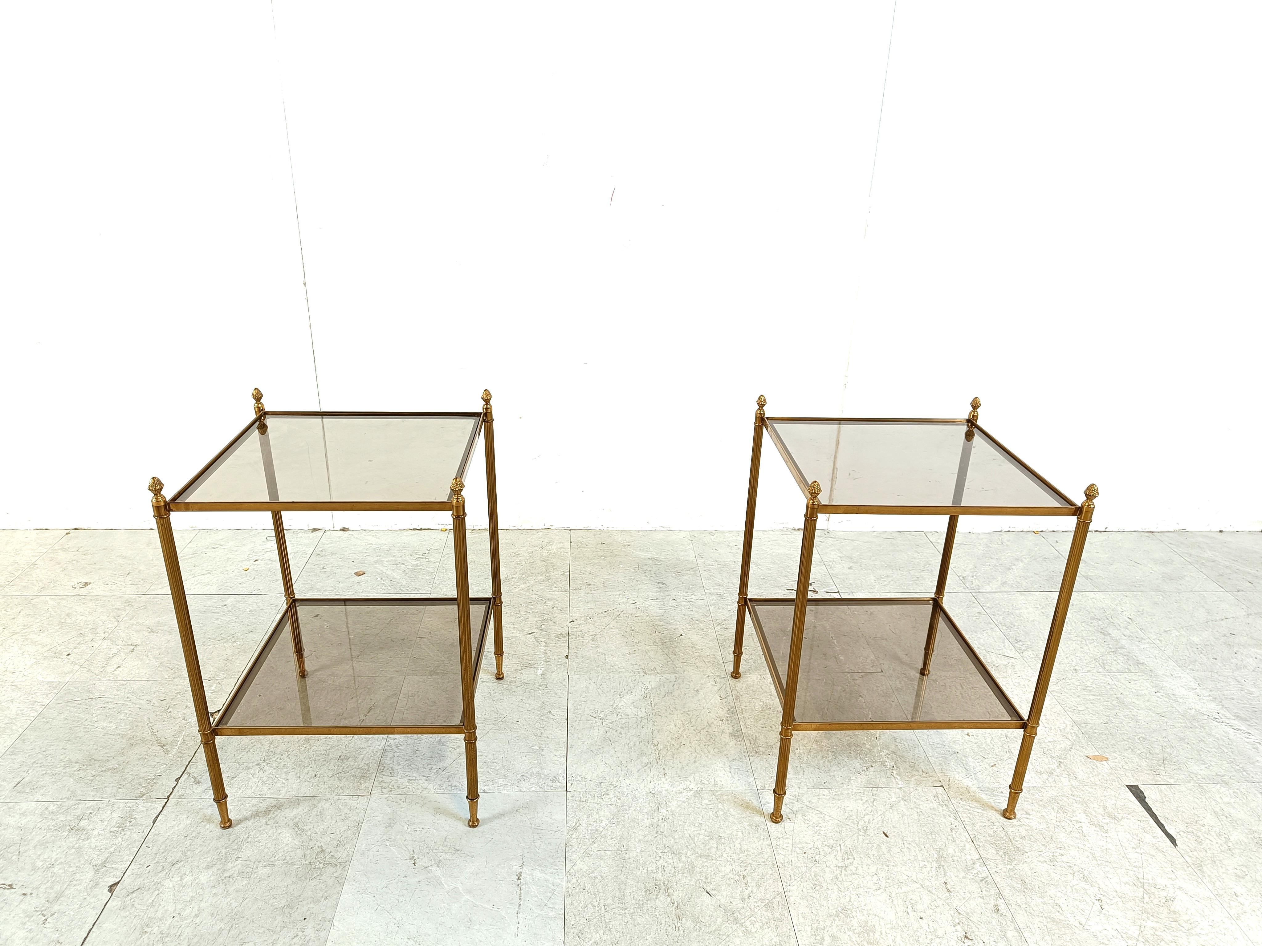 Mid century gbrass acorn side tables by in the manner of Maison Jansen. 

The side tables have two tier smoked glasses.

1960s - France

Dimensions:
Height: 58cm
Width x depth: 40cm

Ref.: 302052
