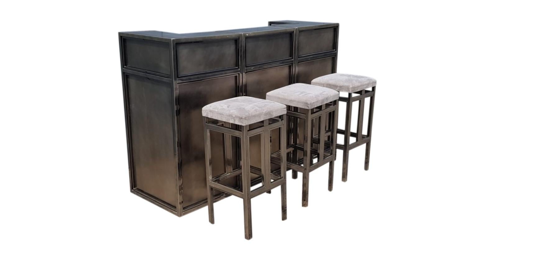Hollywood regency 3-module bar counter made from chrome and brushed steel panels with three matching bar stools.

This high quality bar is a real eye catcher and has a very luxurious appeal.

Good condition.

1970s - France

Length : 180