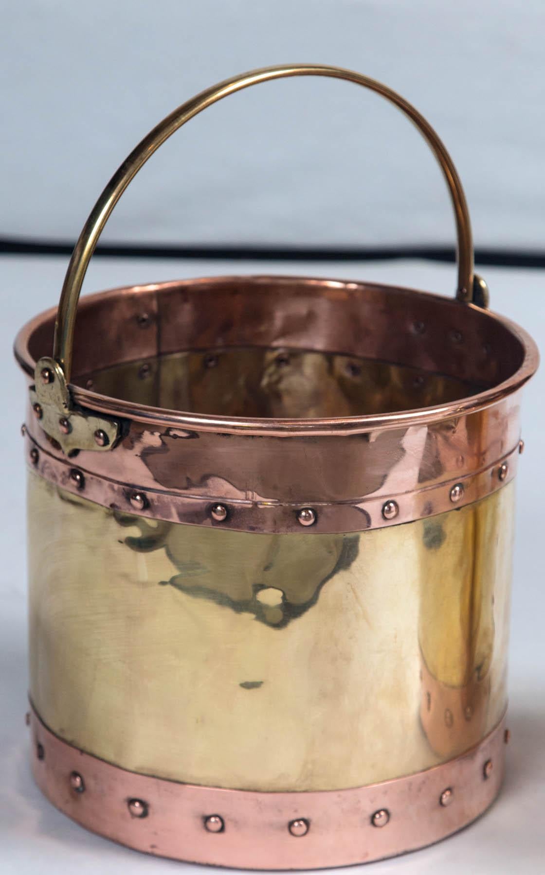 Vintage brass and copper buckets, England, circa early 20th century. Handcrafted with brass handles with riveted copper staves.