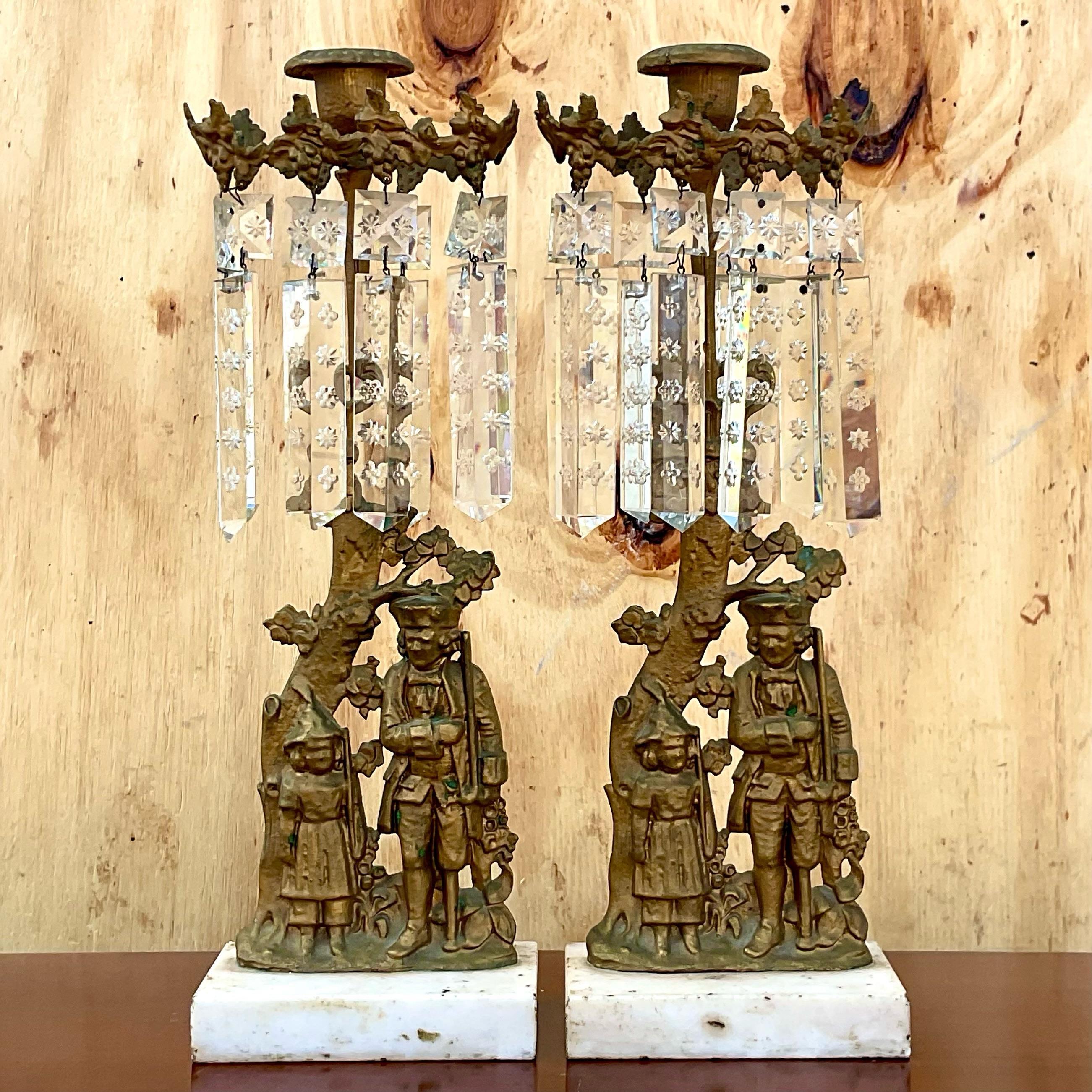 Vintage colonial soldier and grape vine motif brass candelabra pair with etched crystal. Marble plinth and molded these whimsical candelabras add a touch of nostalgia to any room. Acquired from a Palm Beach estate. 