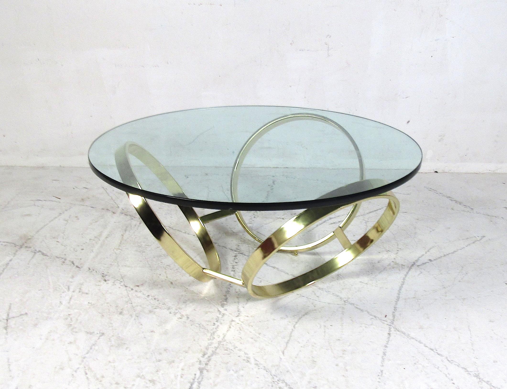Stylish midcentury style brass and glass cocktail table. Interesting sculptural base with a glass top. Please confirm item location with dealer (NJ or NY).