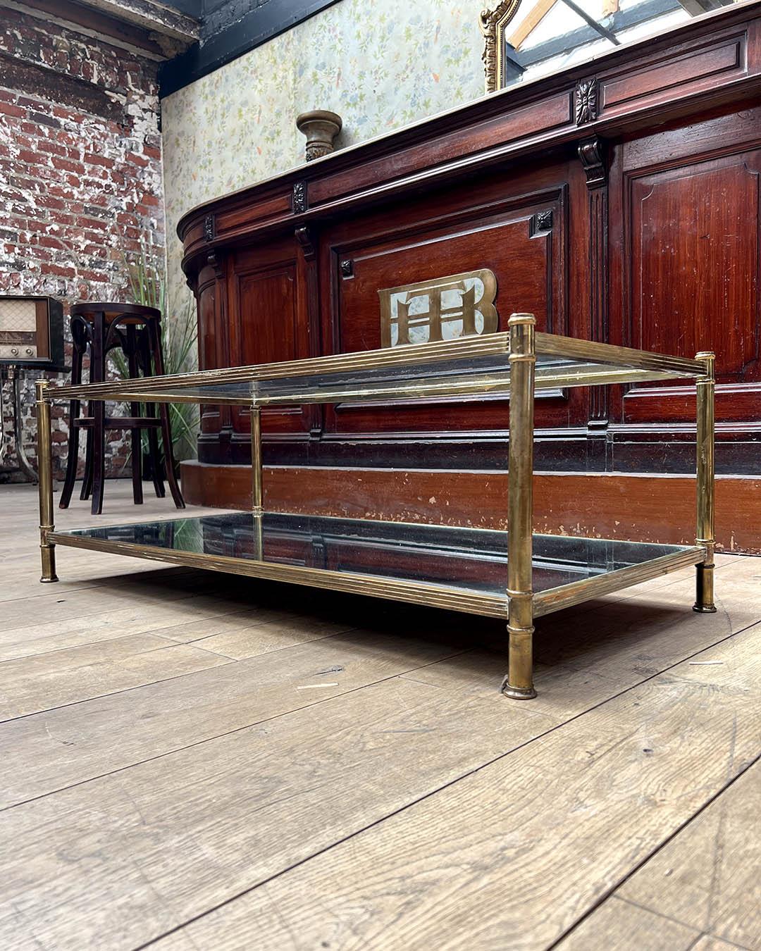 Elegante mesa de centro rectangular de la famosa casa de diseño francesa Roche Bobois, de la década de 1970. Esta pieza presenta una refinada estructura de latón con detalles de inspiración neoclásica, que incluyen patas estriadas y remates