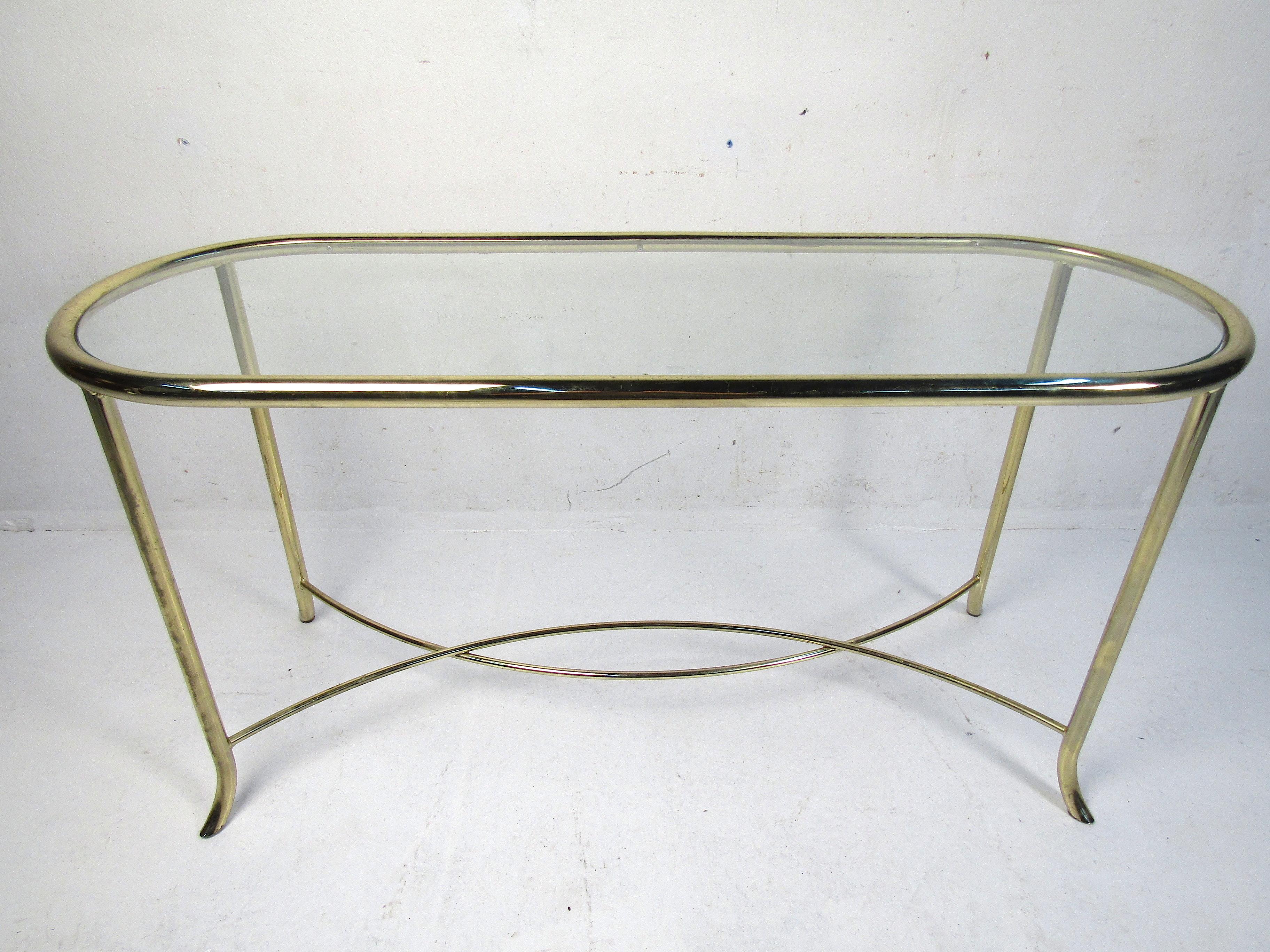Stylish mid-century style console table. Brass colored frame with a glass insert serving as the tabletop. Please confirm item location with dealer (NJ or NY).