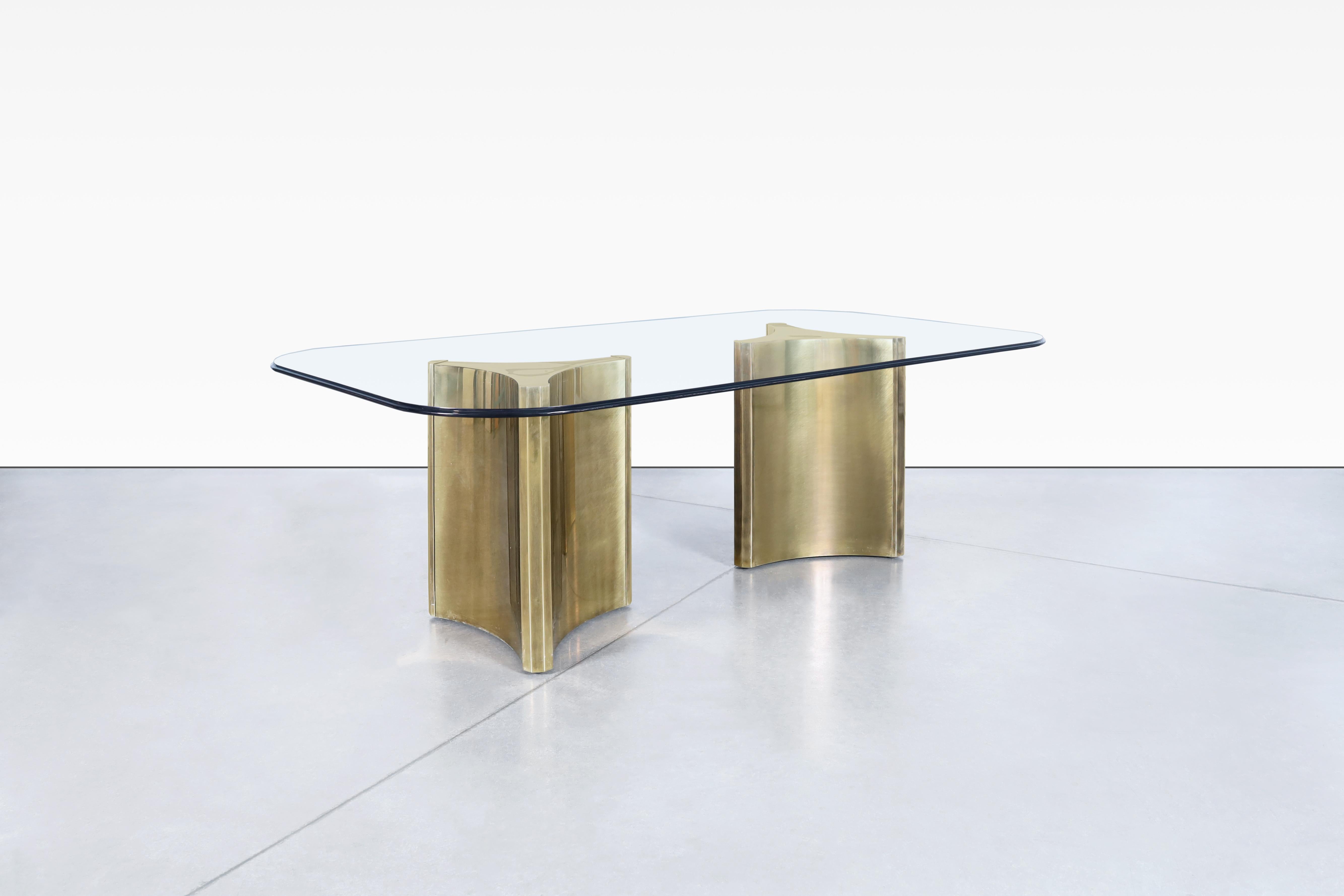 Stunning vintage brass “Trilobi” dining table designed and manufactured by Mastercraft, circa 1970s. Looking for a unique and versatile piece of furniture that will elevate your décor? Look no further than these stunning brass table! From a