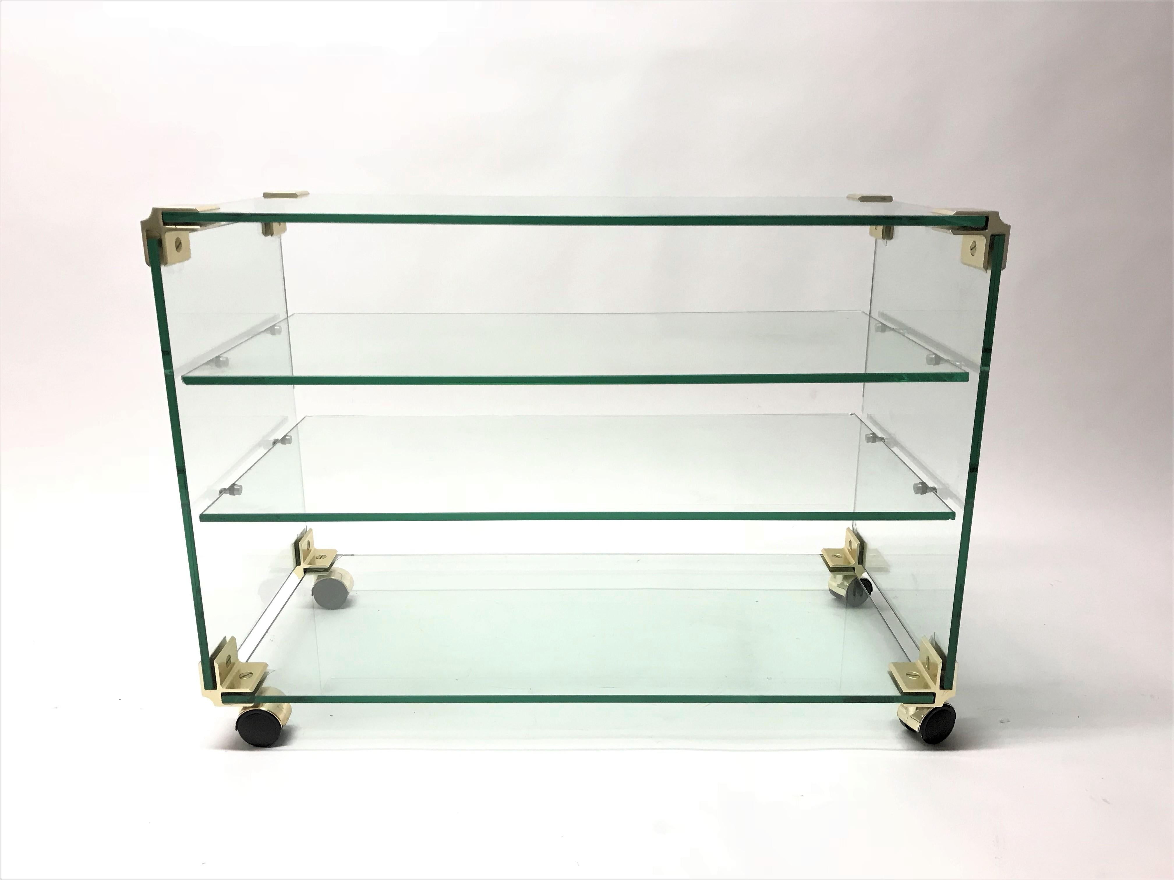 Regency style brass and glass trolley.

The trolley consists of two glass shelves in the middle, the bottom and top make a total of 4 shelves.

Ideal to use as a side table, serving trolley or as a television table.

The manufacturer/designer