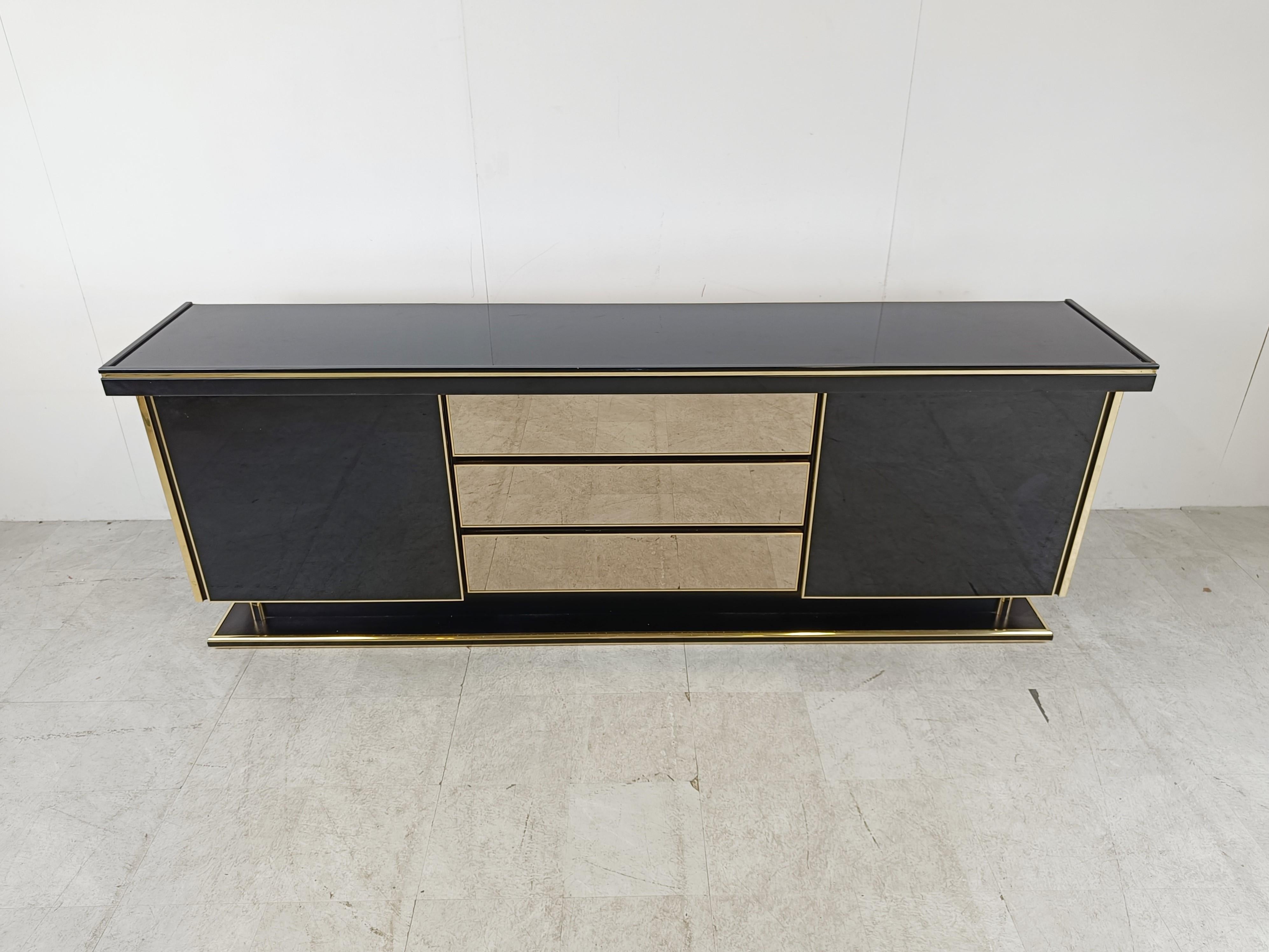Luxurious seventies glamour sideboard consisting of two sliding doors and three smoked mirrored glass drawers.

The use of different high quality materials makes this piece a real eye catcher.

Good condition.

1970s - France

Dimensions:
Lenght: