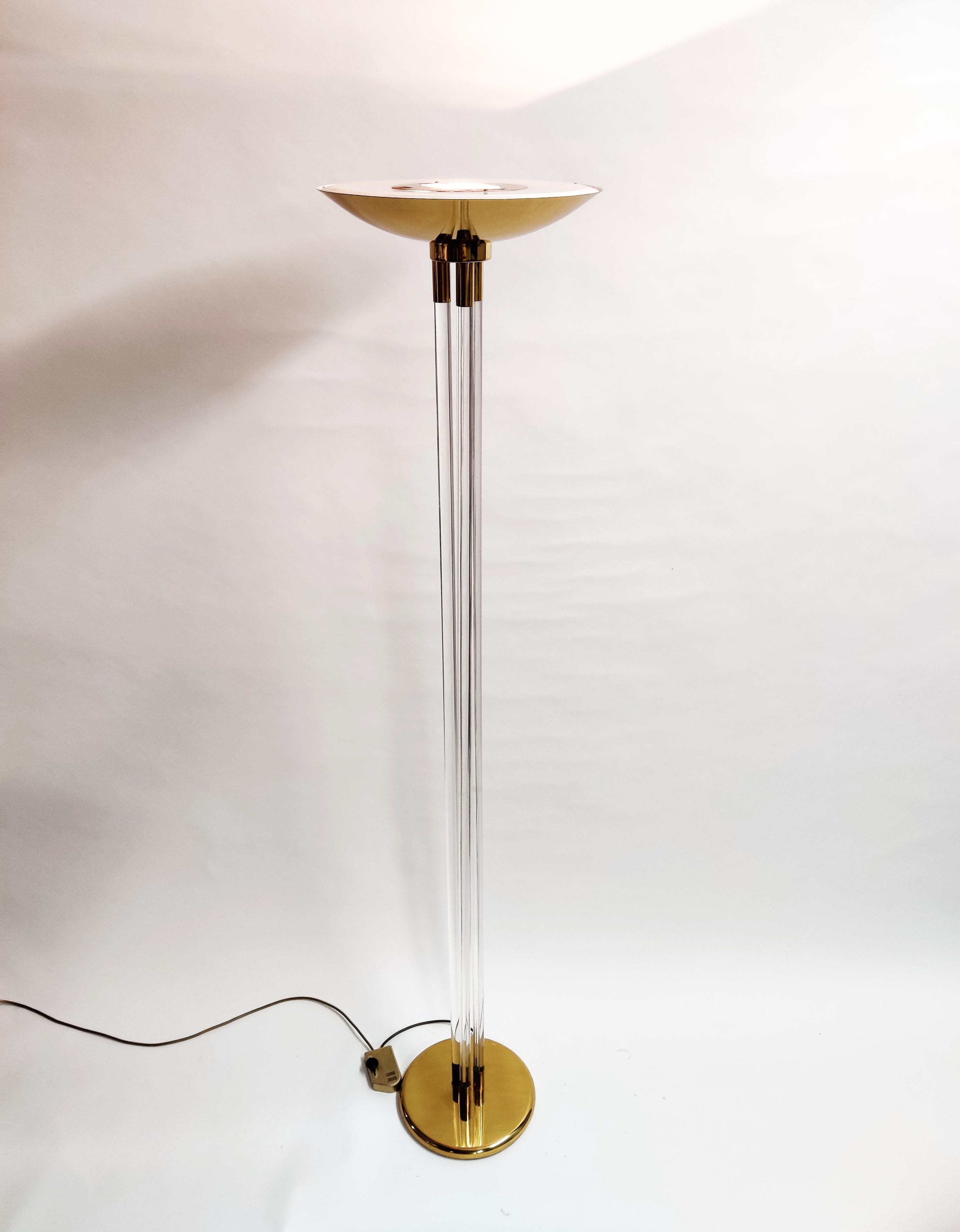 Hollywood regency lucite and brass 'torchiere' floor lamp.

This elegant floor lamp consists of thee lucite legs and a brass base and top.

Beautiful, timeless piece.

Tested and ready to use.

Dimmable light.

1970s - France

Dimensions:
Height: