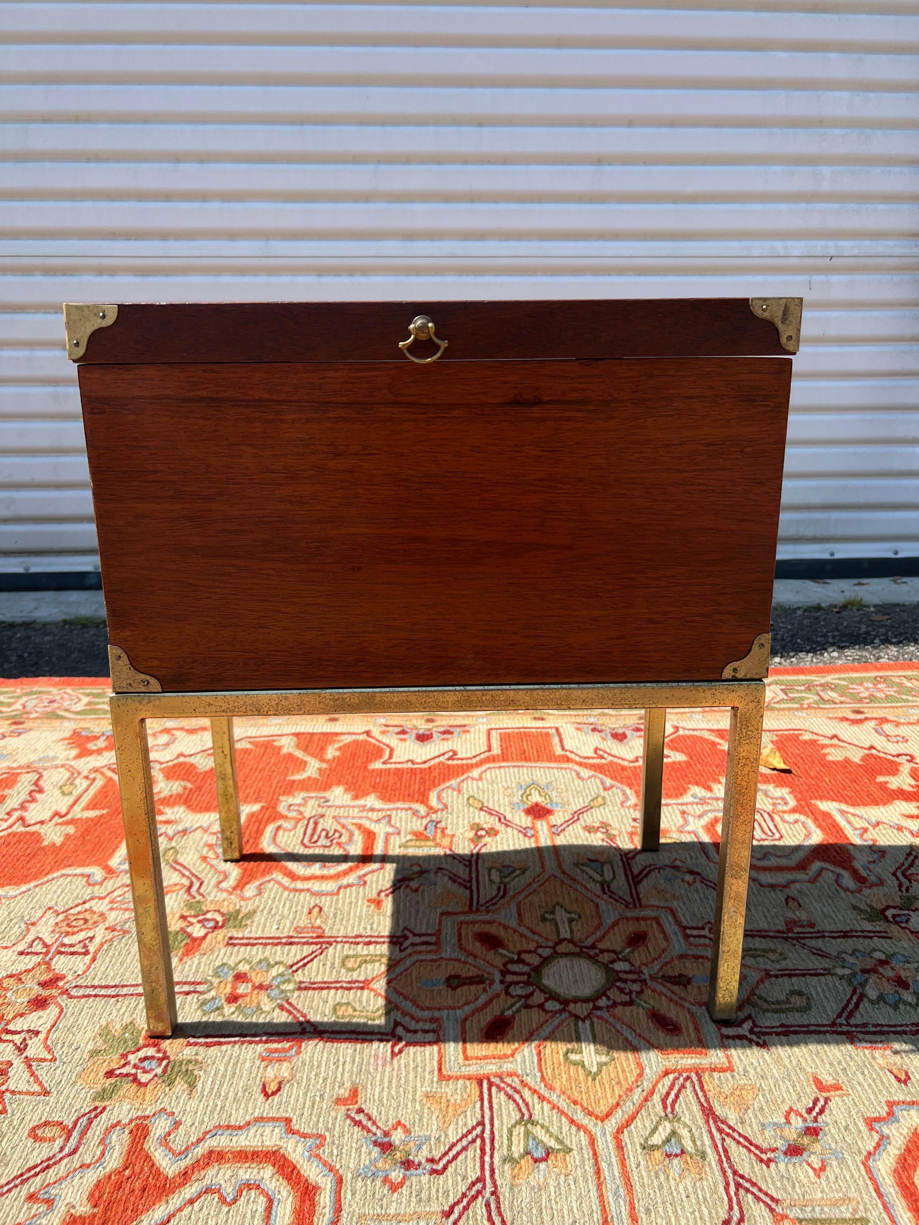 A mahogany campaign style box on stand, The box with brass corners and handles, with attached parson style brass base. The finish in excellent condition. 18 inches high, 21 inches wide, 12 inches deep