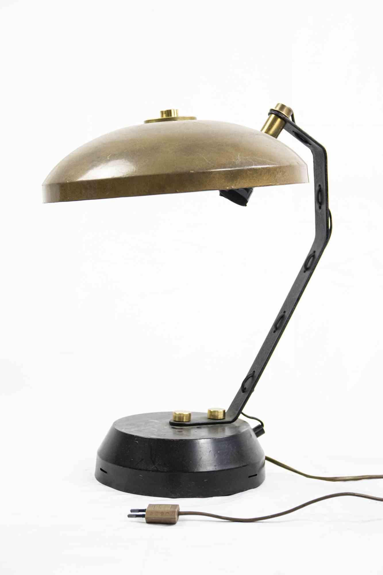 Vintage brass and metal table lamp is an original design lamp realized in the 1970s.

A vintage lamp with the lampshade in brass and with the black plastic base.

Good conditions except for signs due to the time.
