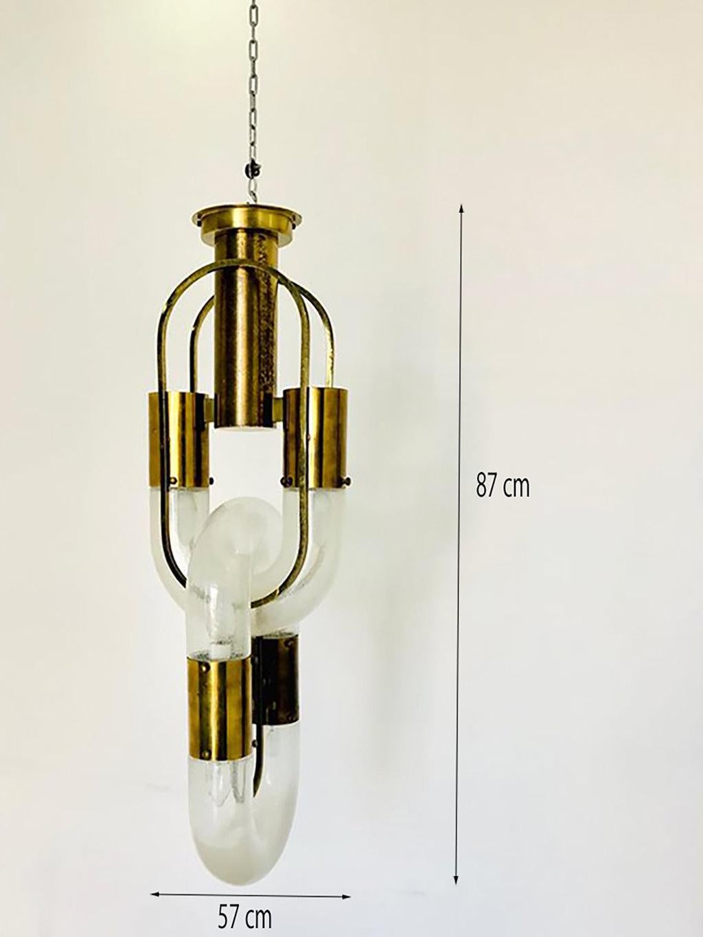 This brass and Murano glass chandelier is an original decorative object designed by the Italian glassworker Aldo Nason and realized by the prestigious Glassware Mazzega in Venice in the 1970s.

It is, in particular, a six-light chandelier, made of