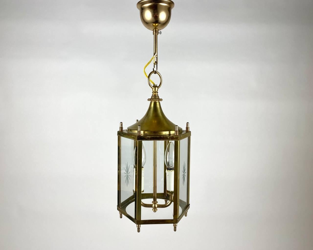 Vintage handcrafted chandelier- lantern for two light points made in 1970-1980s. 

A chandelier from the manufacturer is an amazing combination of warranty from the manufacturer and the design of the lighting fixture.

The hexagonal shade comes