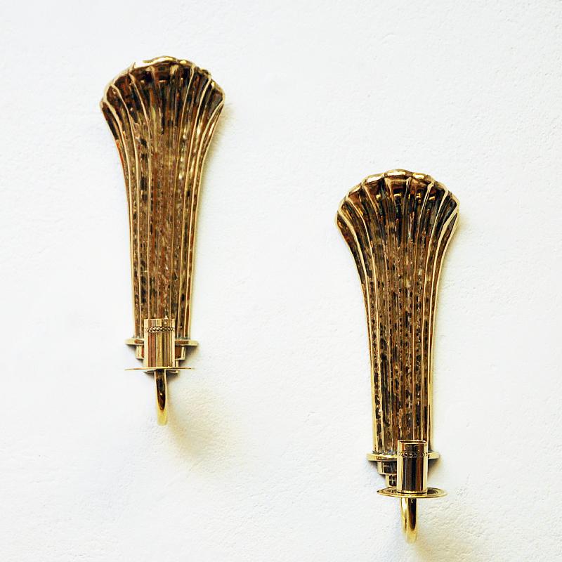 Very lovely art deco brass candlestick holders by Swedish designer Lars Holmström, Arvika - Sweden 1960s. The holders are for wall hanging and they give a nice shine when a candle is lit. Stamp on the back with Lars Holmström, Arvika. These shell