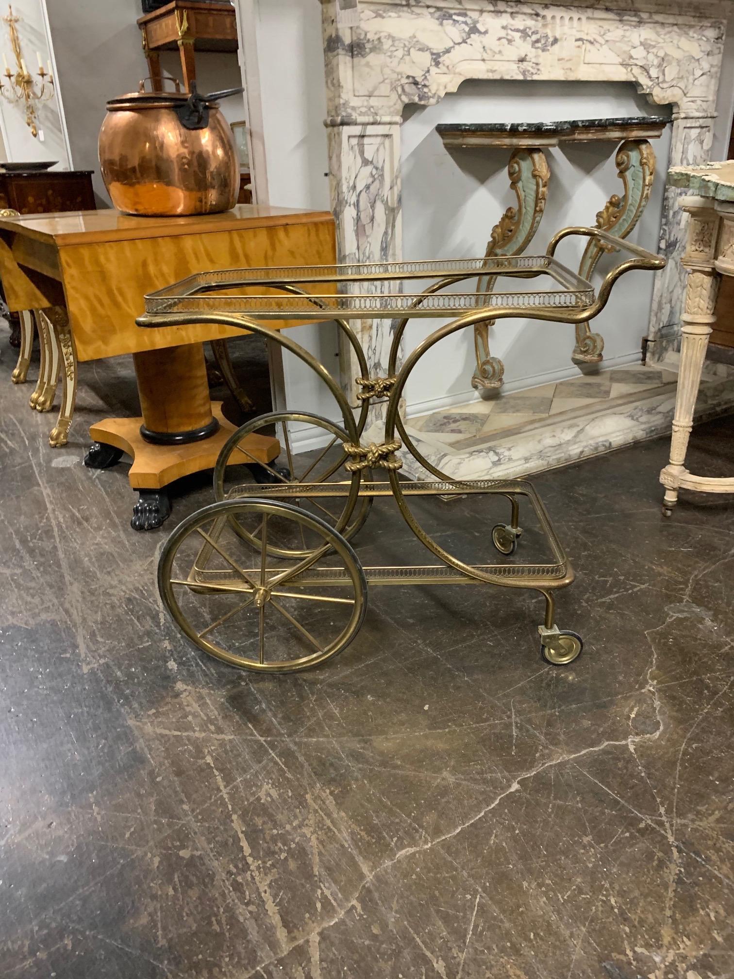 Beautiful decorative vintage brass bar cart. The piece has a glass top and another glass shelf on the bottom. A great accessory!