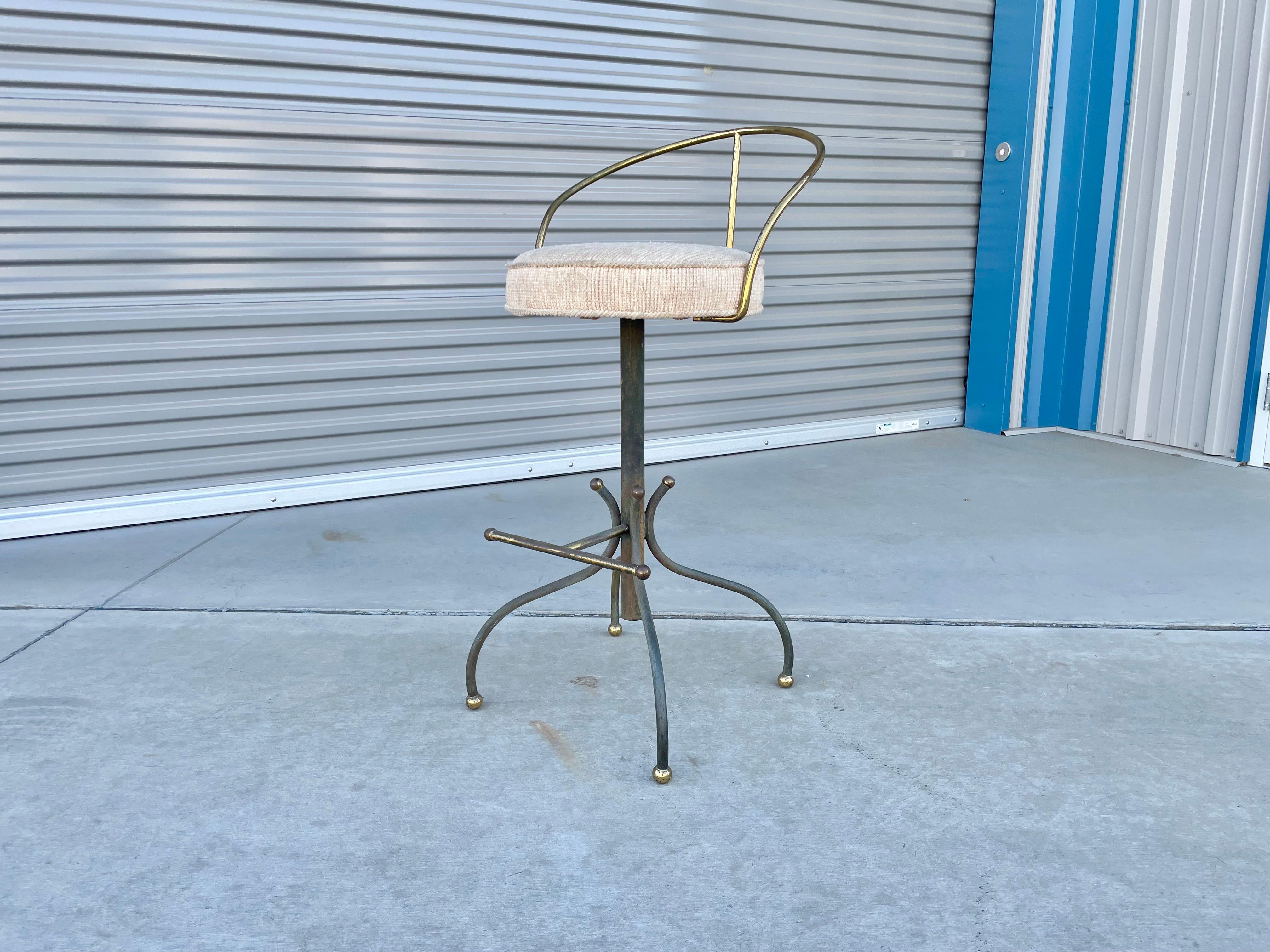 Ce magnifique tabouret de soutien-gorge vintage en laiton a été conçu et fabriqué par Charles Hollis Jones aux États-Unis dans les années 1960. Ce tabouret de bar est doté d'un dossier en laiton qui offre un grand confort et un bon maintien du