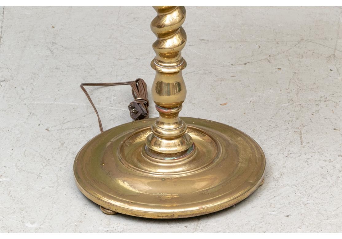 A vintage twin light lamp table in fine brass with barley twist top and lower supports and round brass table. Mounted on a raised circular base. Lacking a shade. With great weight and solidity. 
Measures: Height 56 1/2