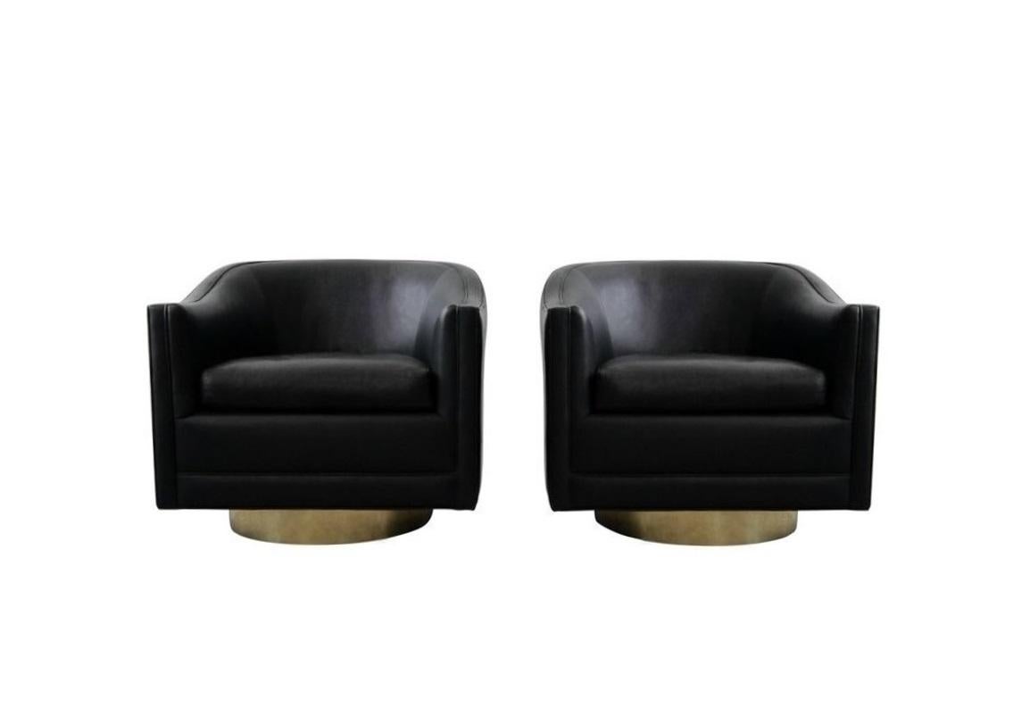 Pair of glamorous 1970s velvet swivel lounge chairs. Clean modern lines combine with classic leather to give these barrel chairs a timeless look and the gleaming brass swivel bases bring visual interest. The straight arms complement the round back