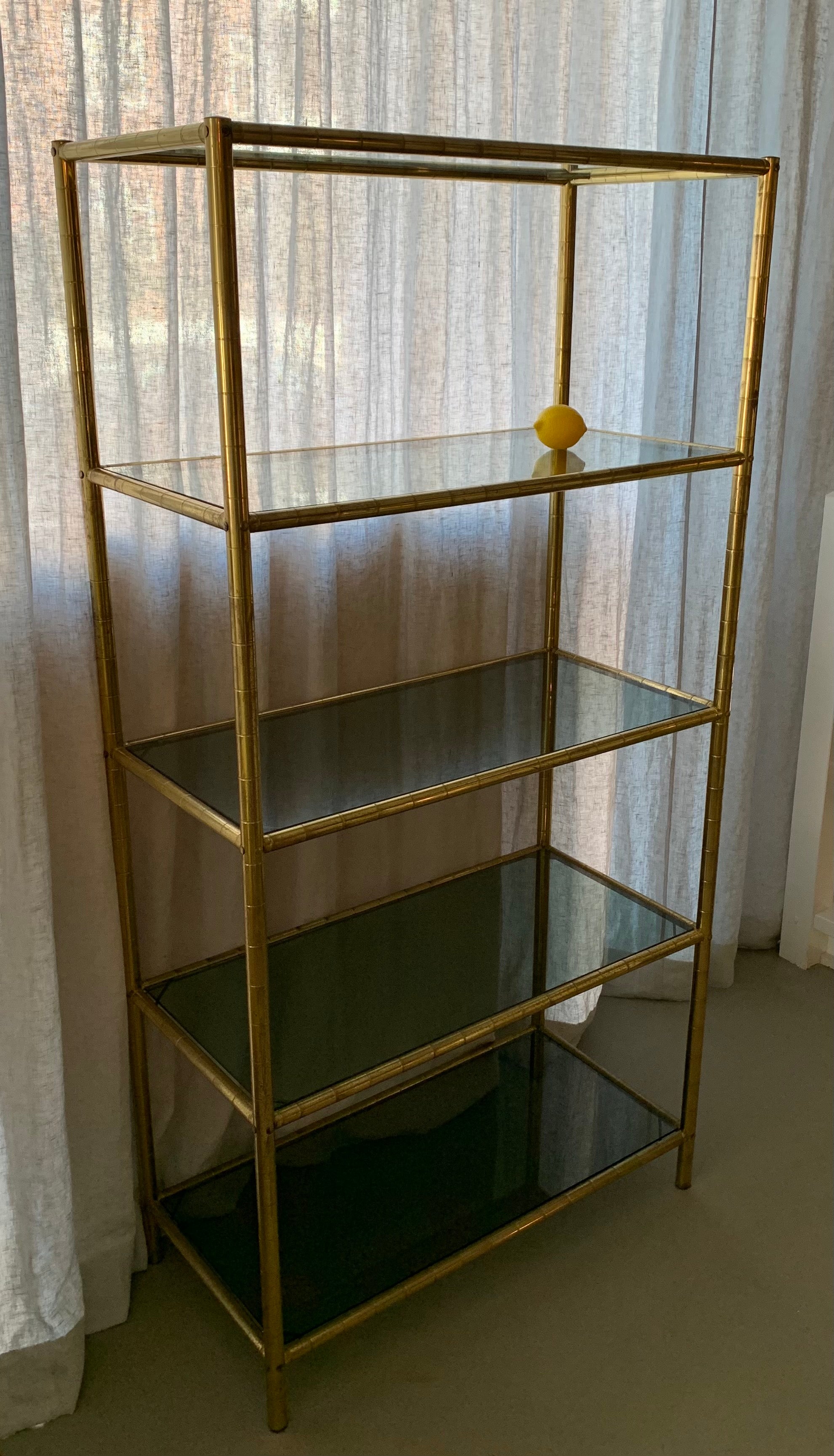 Cool French vintage 1970s bookcase or display unit. The decorative - Faux Bambou - brass base holds 5 smoked glass shelves.
