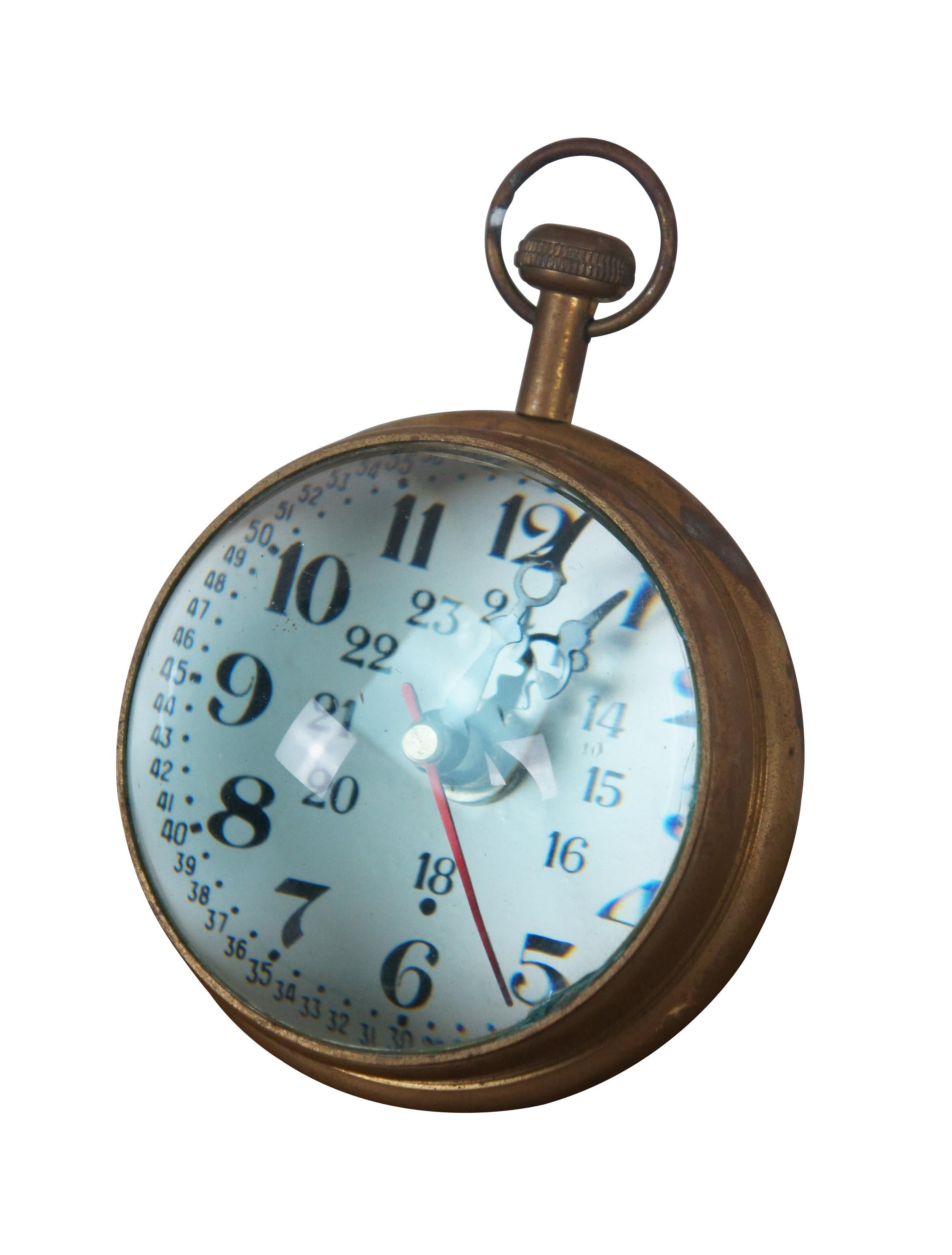 Late 20th century desk clock, crafted in the shape of a Marine pocket watch with brass frame and domes of magnifying glass on the front and back. White face with Arabic numerals, including seconds and 24 hour time. Made in India. M2188 Quartz