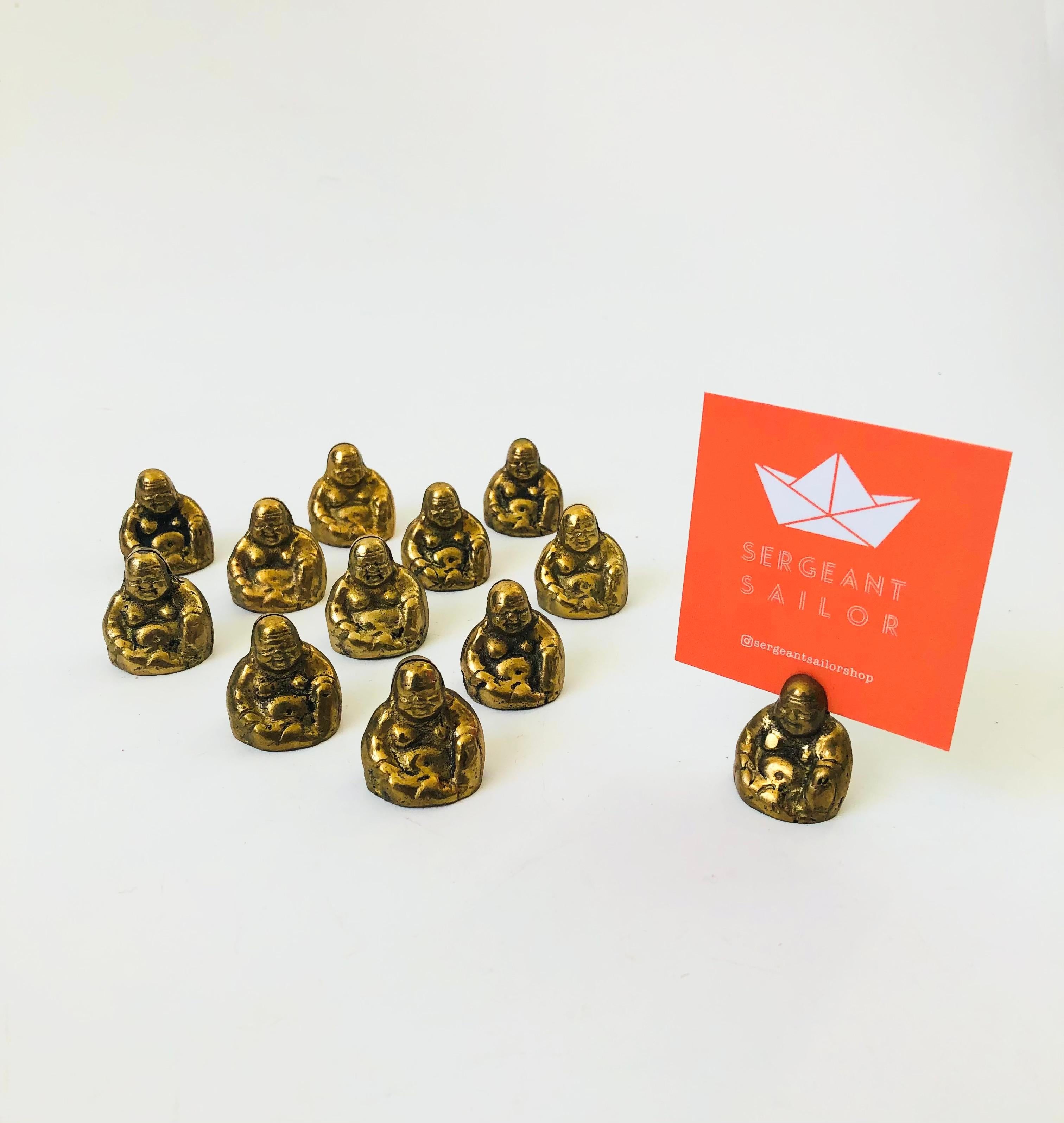 A set of 12 brass buddha place card holders. Each with a slot on top for holding a note. Nice heavy weight to the buddhas.

