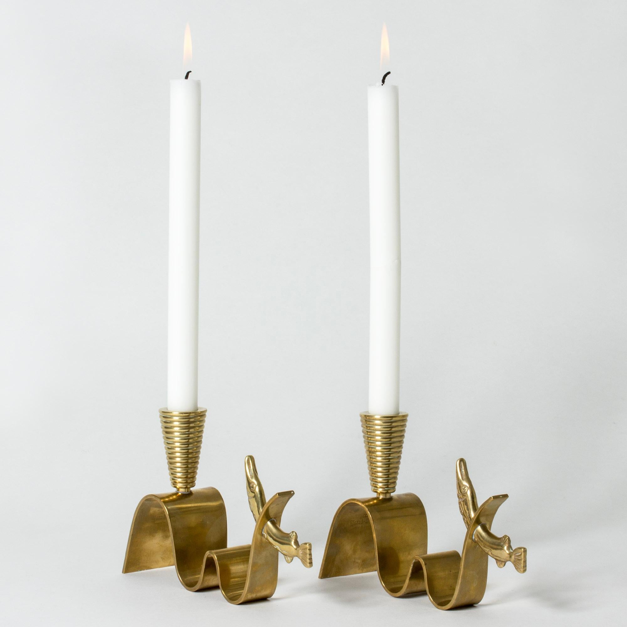 Pair of beautiful “Tyfon” candlesticks by Carl-Einar Borgström, made from brass in a whimsical design. Pikes are caught in stylized waves with a dynamic expression.