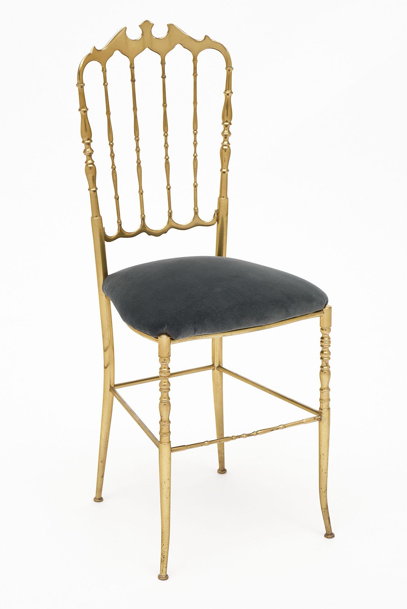 Pair of chairs, of solid gilded brass, Italian, with newly upholstered seats in a gray velvet blend. Chiavari chairs are named for the Italian city where they originated. This little town, located between Genoa and the Cinque Terre, began producing