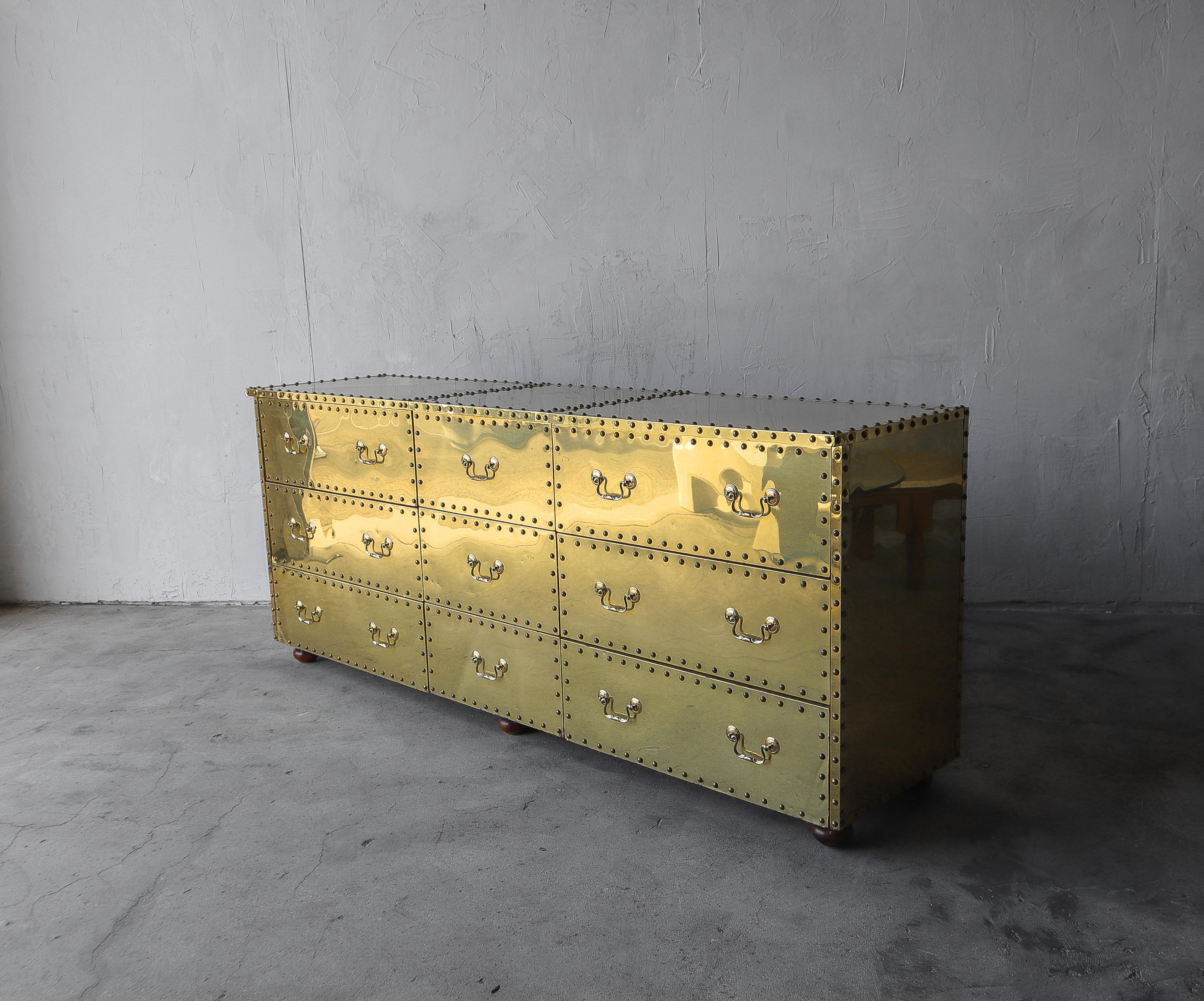 Love brass, look no further. The beautiful brass clad and riveted nine-drawer dresser by Sarreid Ltd.

Minor patina, dings, dents, and fine scratches from age and use, not perfect but overall pretty good condition, see images.

     
   