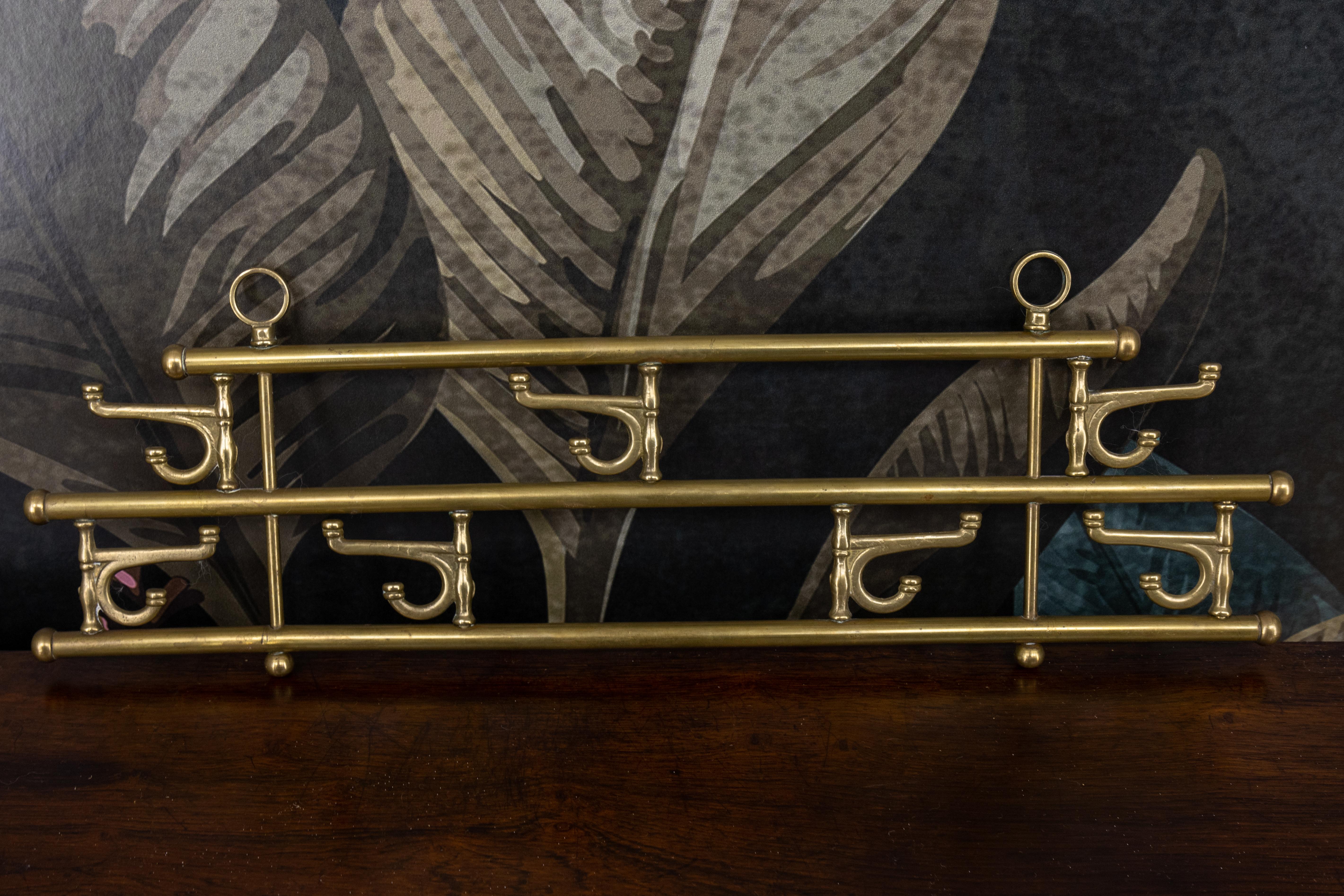 Appendiabiti vintage in ottone della metà del secolo scorso con sette ganci girevoli, Austria, circa 1960. 
Questo portaoggetti decorativo è ideale per asciugamani, oggetti da cucina o piccoli cappotti. È dotato di sette ganci rotanti in stile
