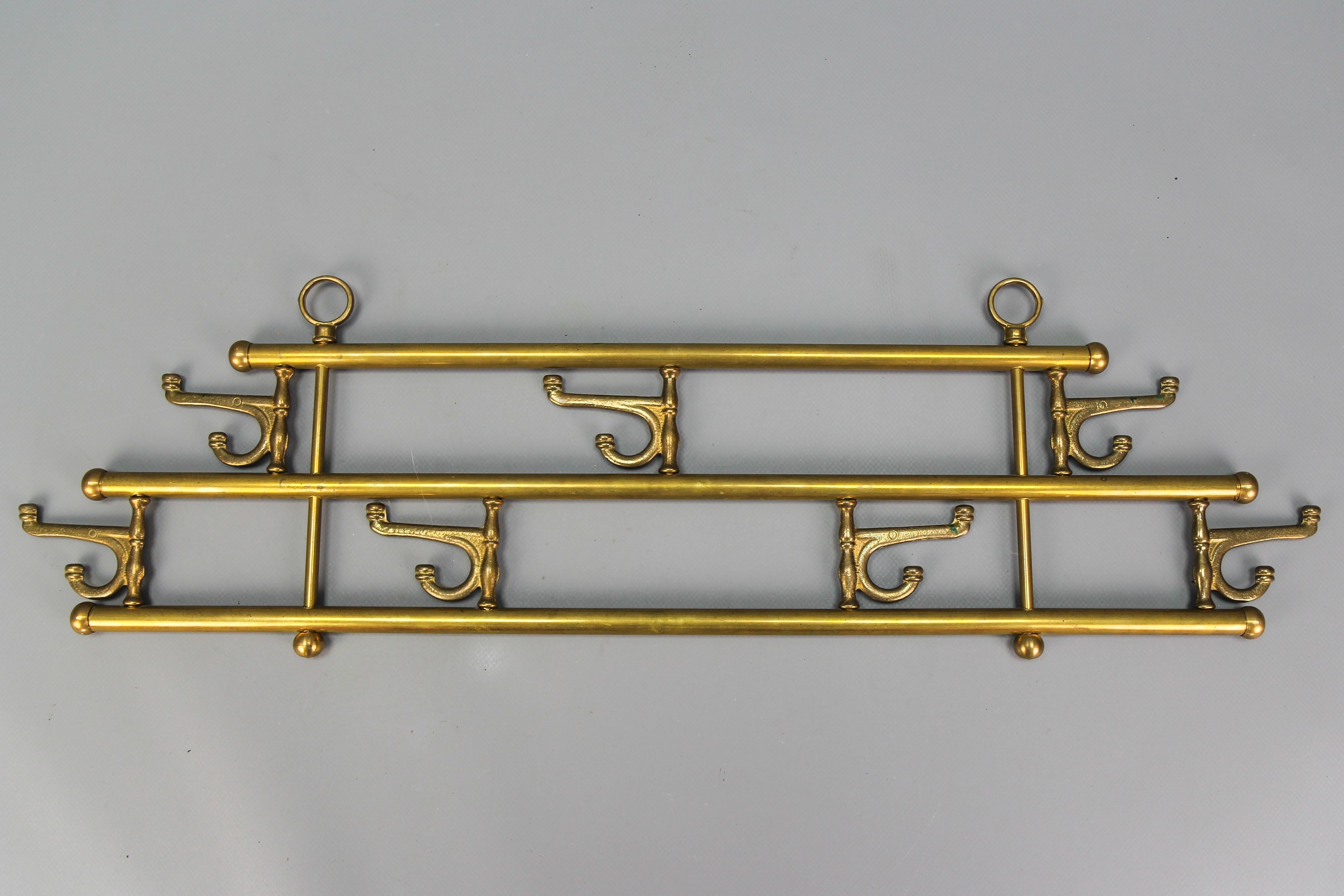 Vintage Mid-Century Modern brass coat rack with seven swiveling hooks, Austria, circa the 1960s.
Decorative towel, kitchen, or small coat brass rack with seven rotating modernist-style hooks that can be swiveled.
It is attached with 2 rings that can