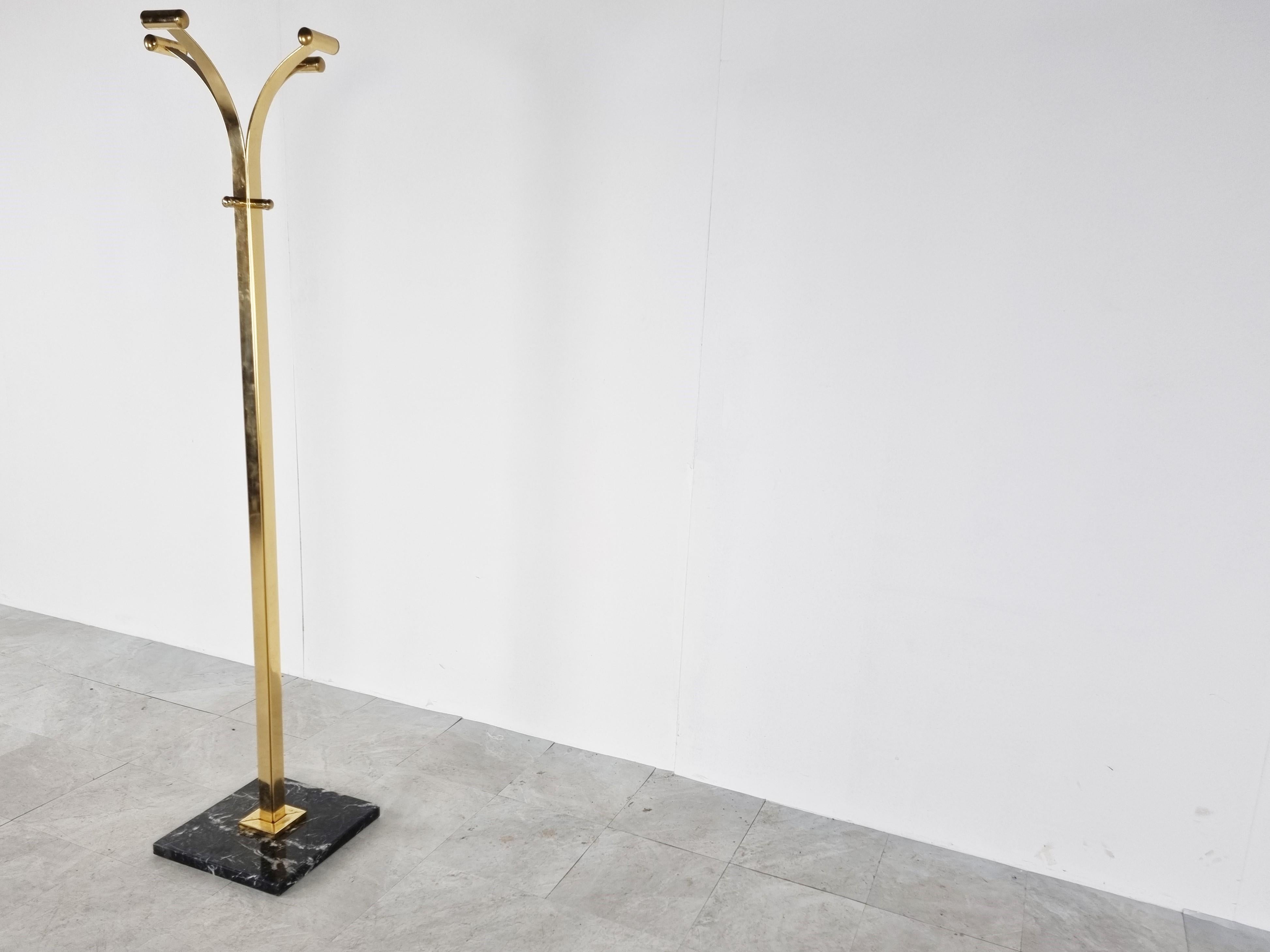 Modernist brass coat stand with a black marble base providing 4 hooks.

Elegant design.

Good overall condition, one of the arms has some brass loss on the inside.

1970s - Italy

Dimensions:
Height: 170cm/66.92