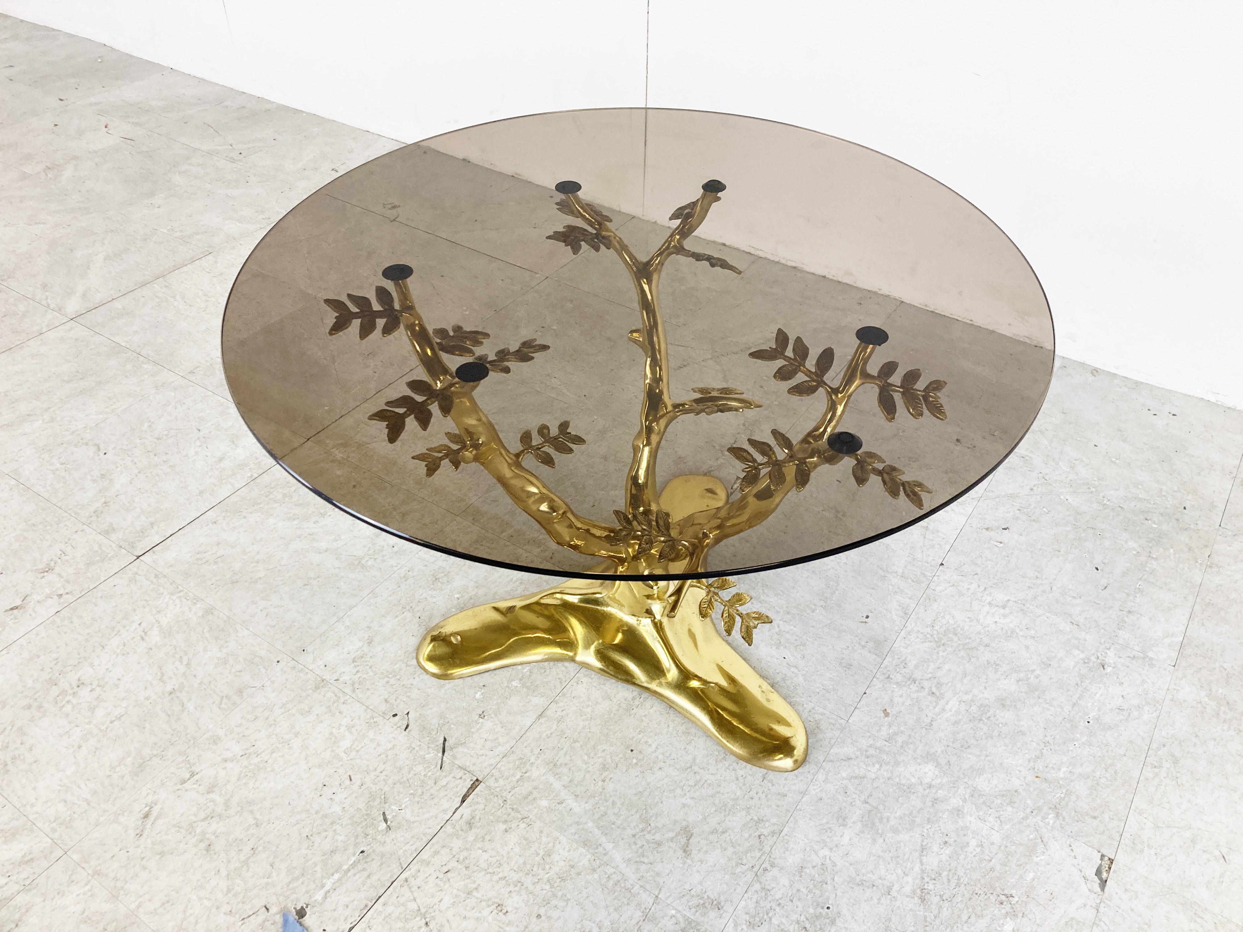 Table basse sculpturale en forme d'arbre en laiton avec un plateau en verre rond fumé.

Belle table basse décorative.

Bon état

Années 1970 - Belgique

Dimensions :
Hauteur : 48cm/18.89
