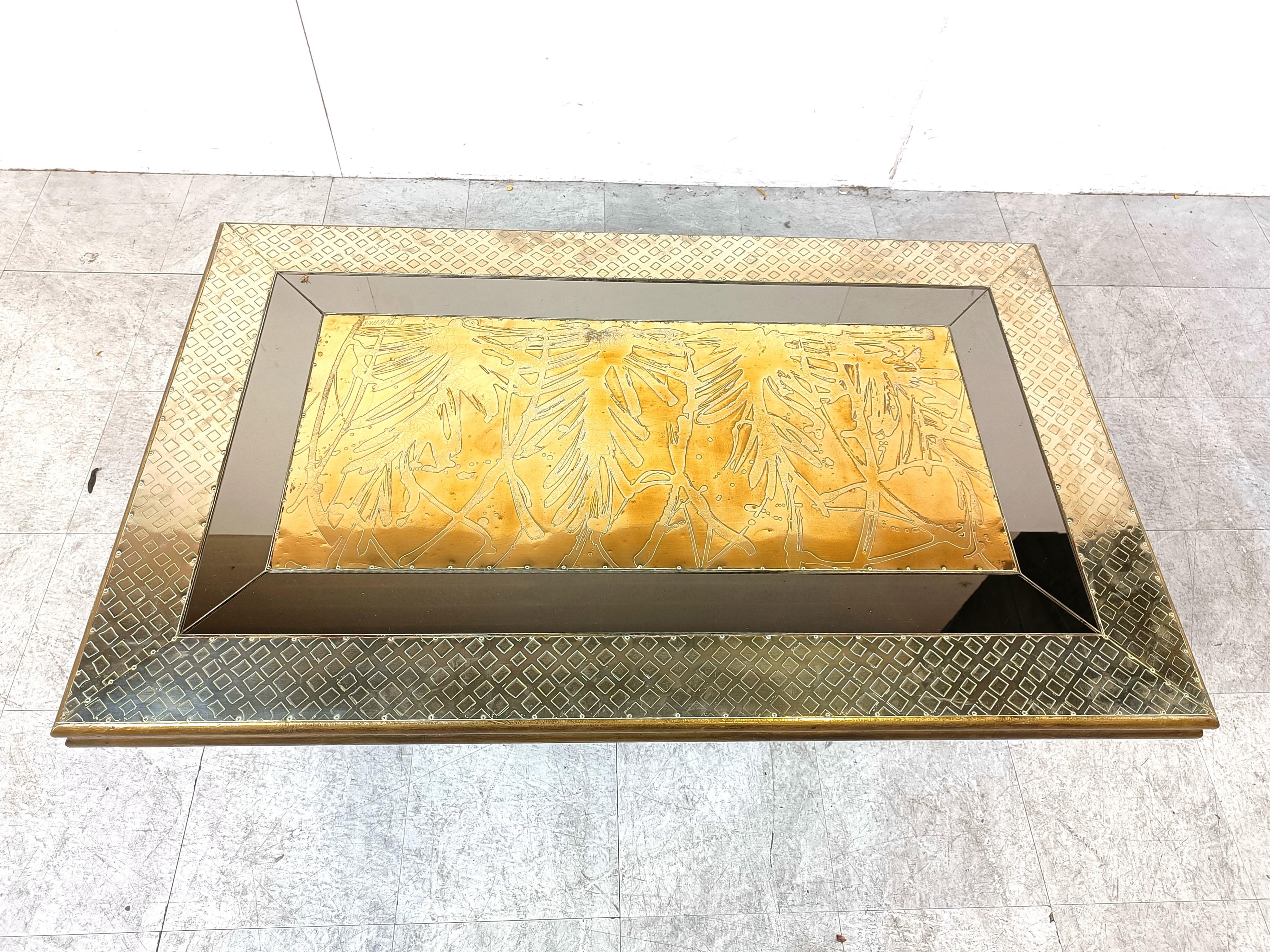 Impressionnante table basse de Rodolfo Dubarry.

La table est en bois recouvert de feuilles de laiton martelées et d'incrustations d'étain. 

Au centre se trouve une plaque de laiton gravée.

Socle en bois doré.

Bon état général.

Années 1970 -