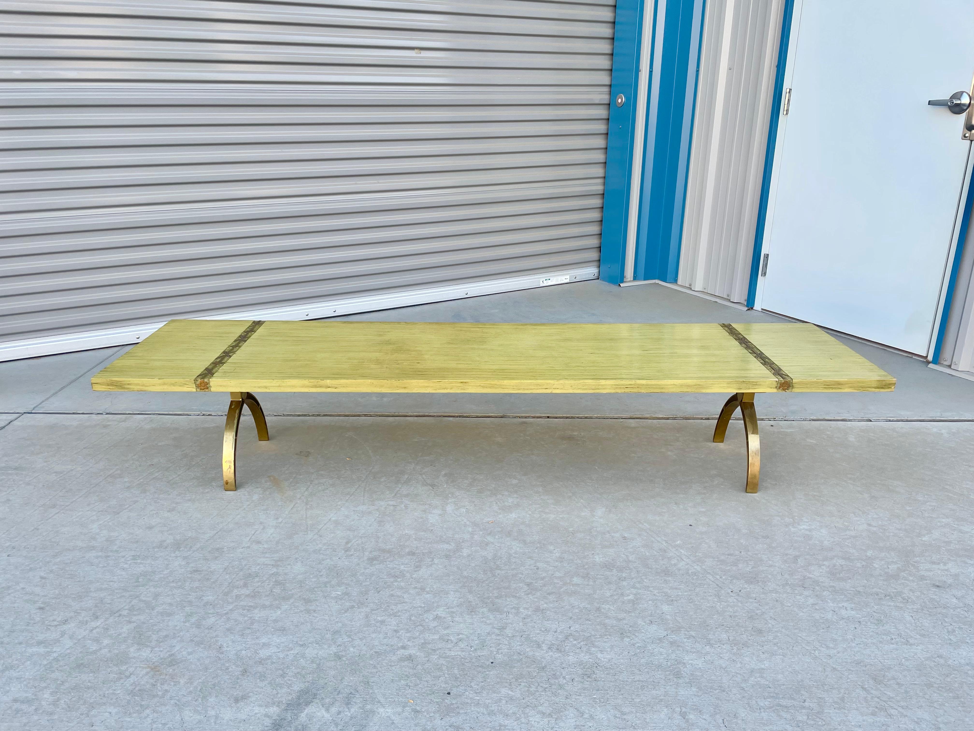 Vintage brass coffee table designed and manufactured in the United States circa 1970s. This beautiful mid-century rectangle coffee table features a wood top with a unique brass leg base design, guaranteed to draw everyone's attention in your next