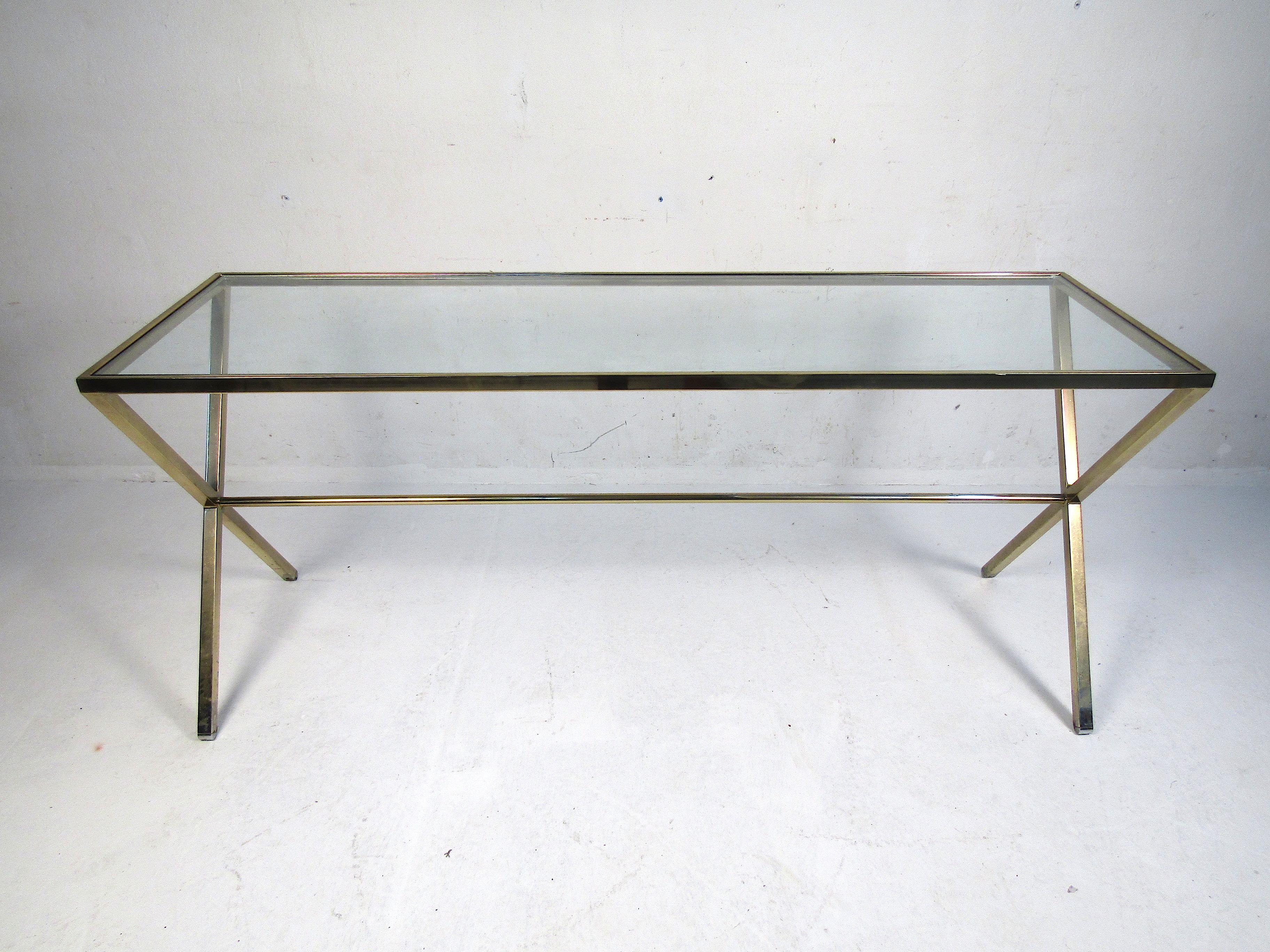 Vintage mid-century style console table with a brass colored frame and a glass insert serving as the tabletop. Interesting design with an X-base and a stretcher running across the underside. Please confirm item location with dealer (NJ or NY).