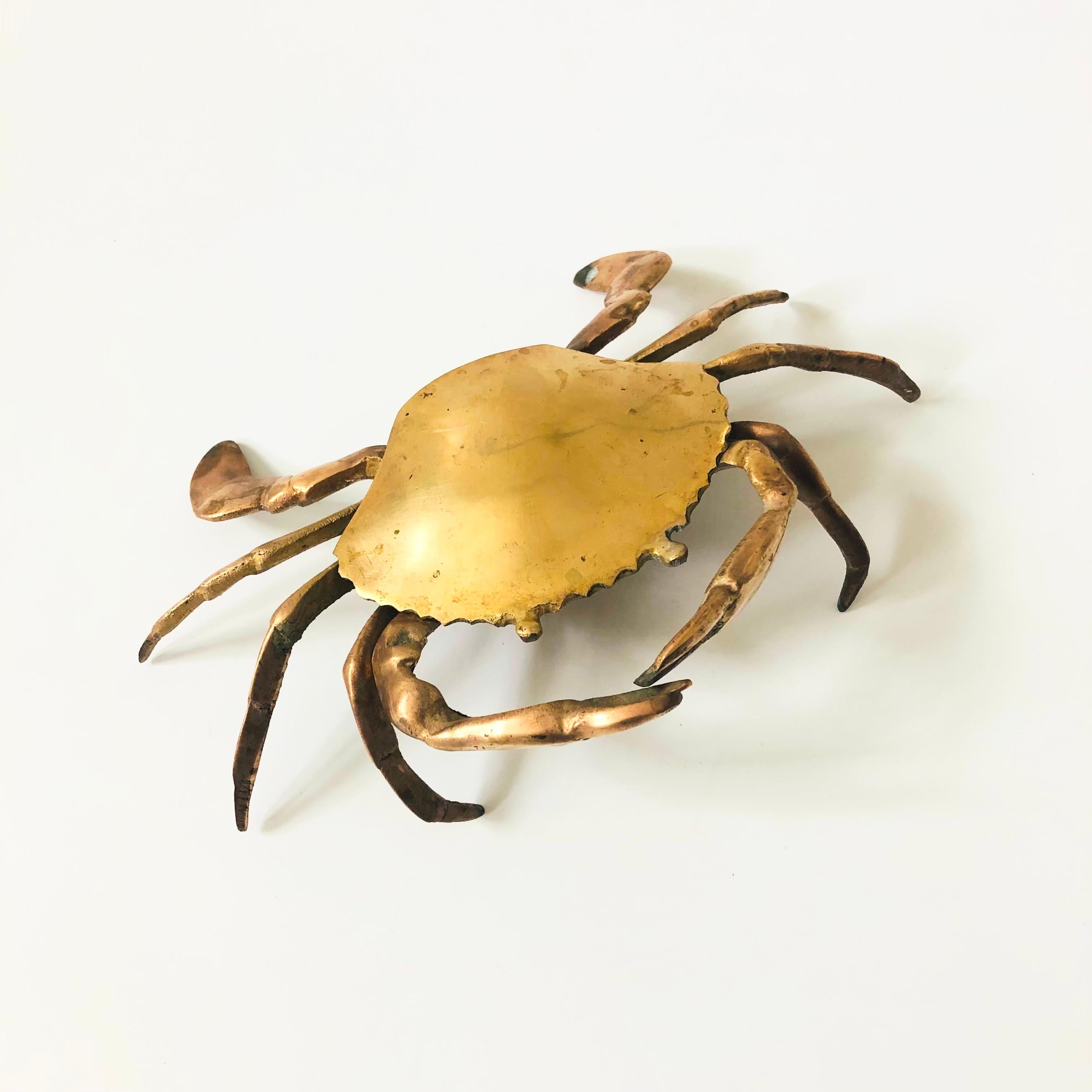A vintage brass box in the shape of a crab. The top hinges open to reveal a small compartment in the center for storing small items. Beautiful detailing formed into the brass to create the crab's features.

