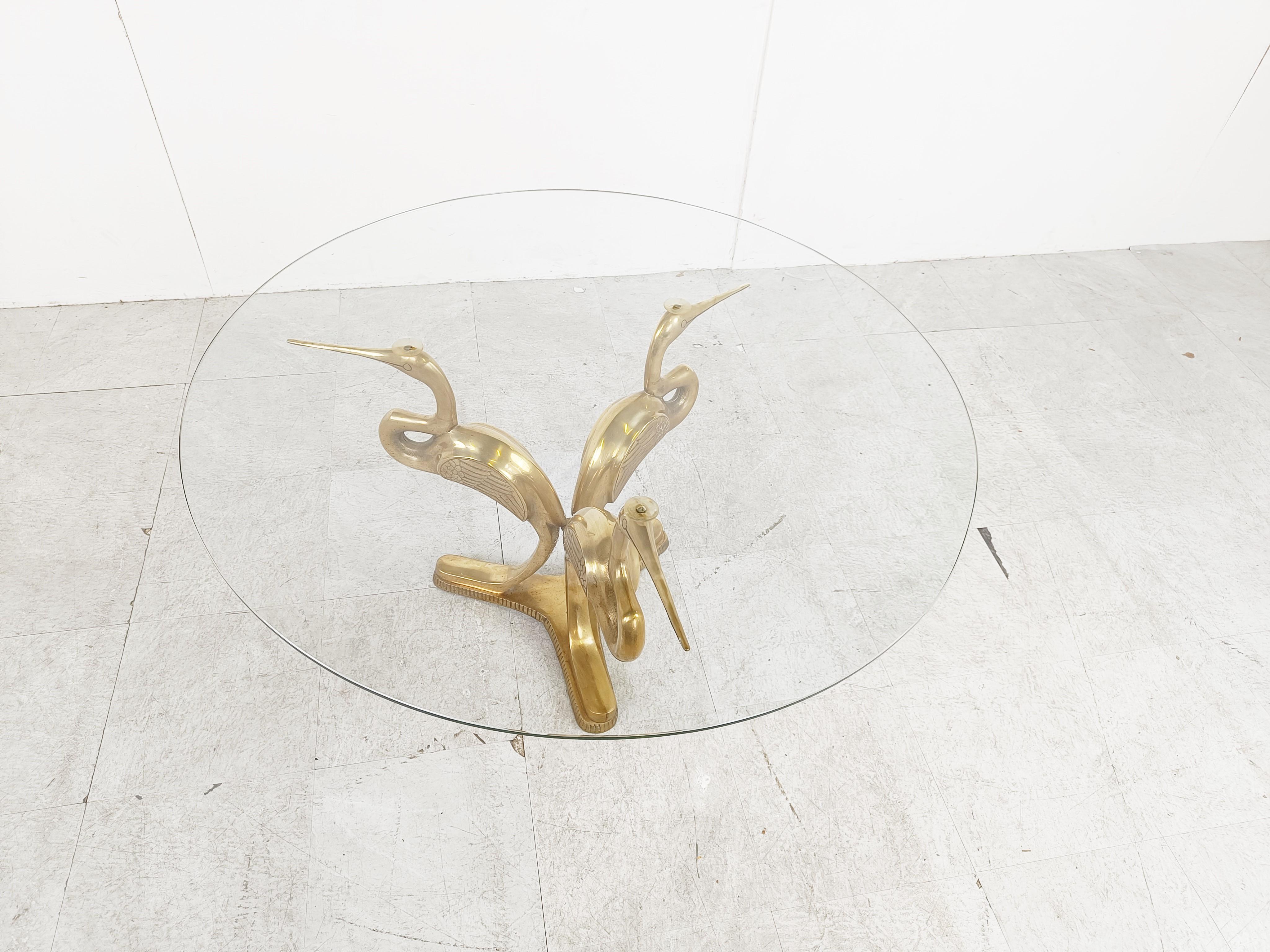 Hollywood regency brass crane bird coffee table.

The coffee table consists of a brass base featuring 3 brass crane birds and a round clear glass top.

We have a pair of these available.

Diemensions:
Height: 50cm/19.68
