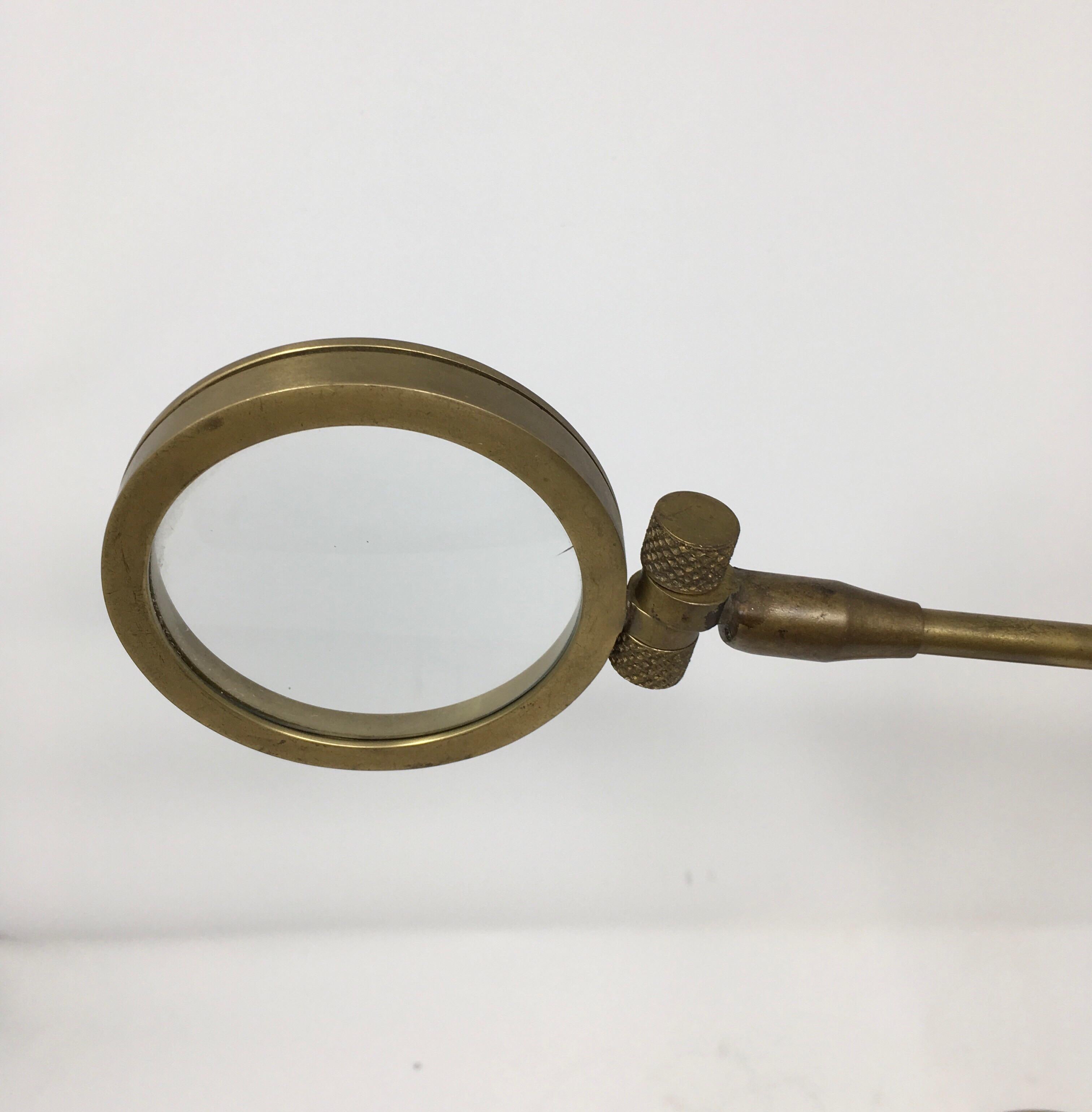 This vintage brass magnifying glass is constructed to be adjustable vertically and horizontally as well as at various angles. Magnifying lenses on stands of this type are used by jewelers, collectors, and others who need to inspect or work with tiny