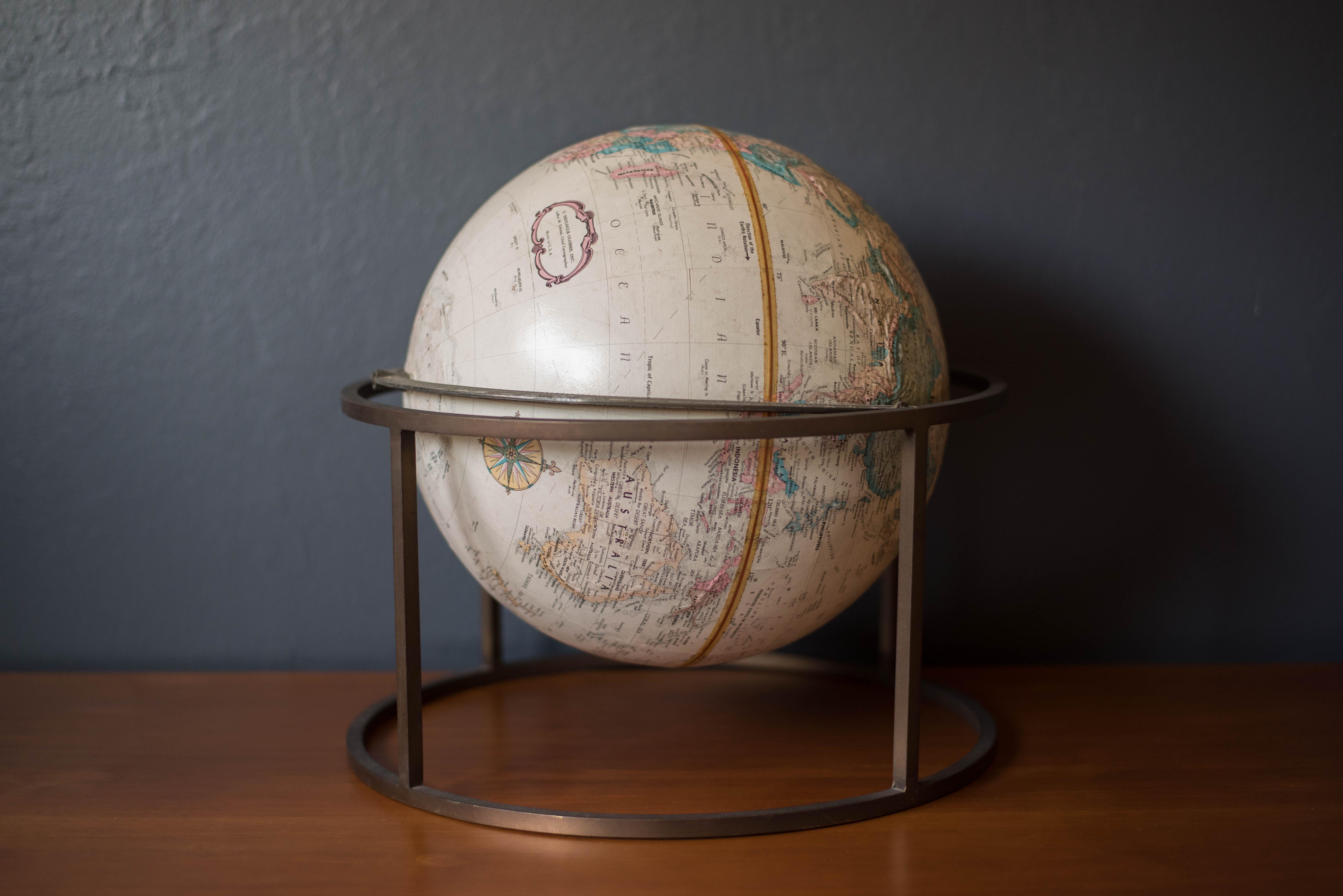 Vintage desk or tabletop Repogle globe with stand in brass. This piece rotates on a full swing meridian and displays plenty of vintage charm. The perfect accessory piece for any home office or library room.