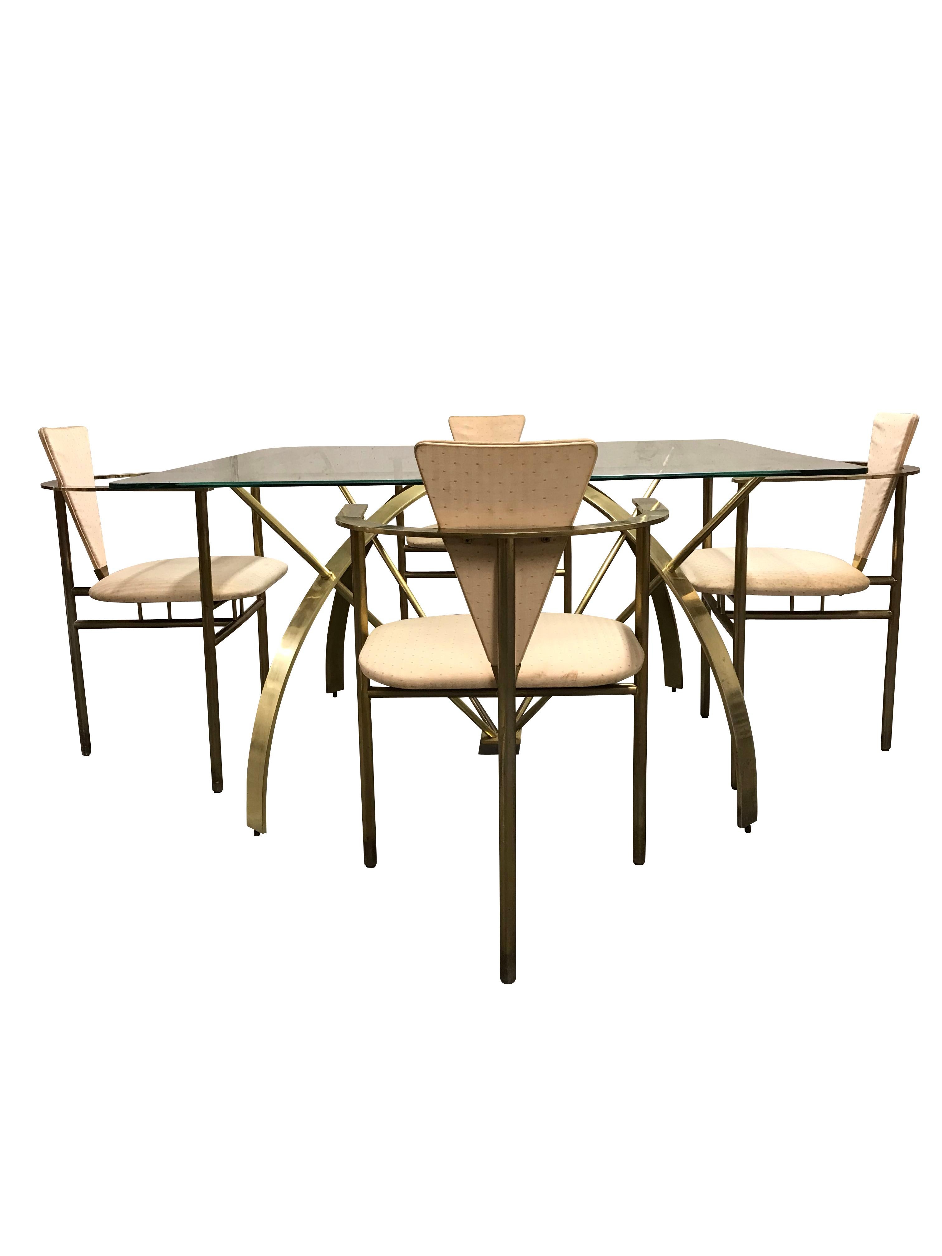Rare brass dining table with a square, partially frozen, glass top.

The set has in fact six chairs but the glass accommodates only four, the glass can be change if desired.

The atomic-like design of the table combined with the tripod chairs