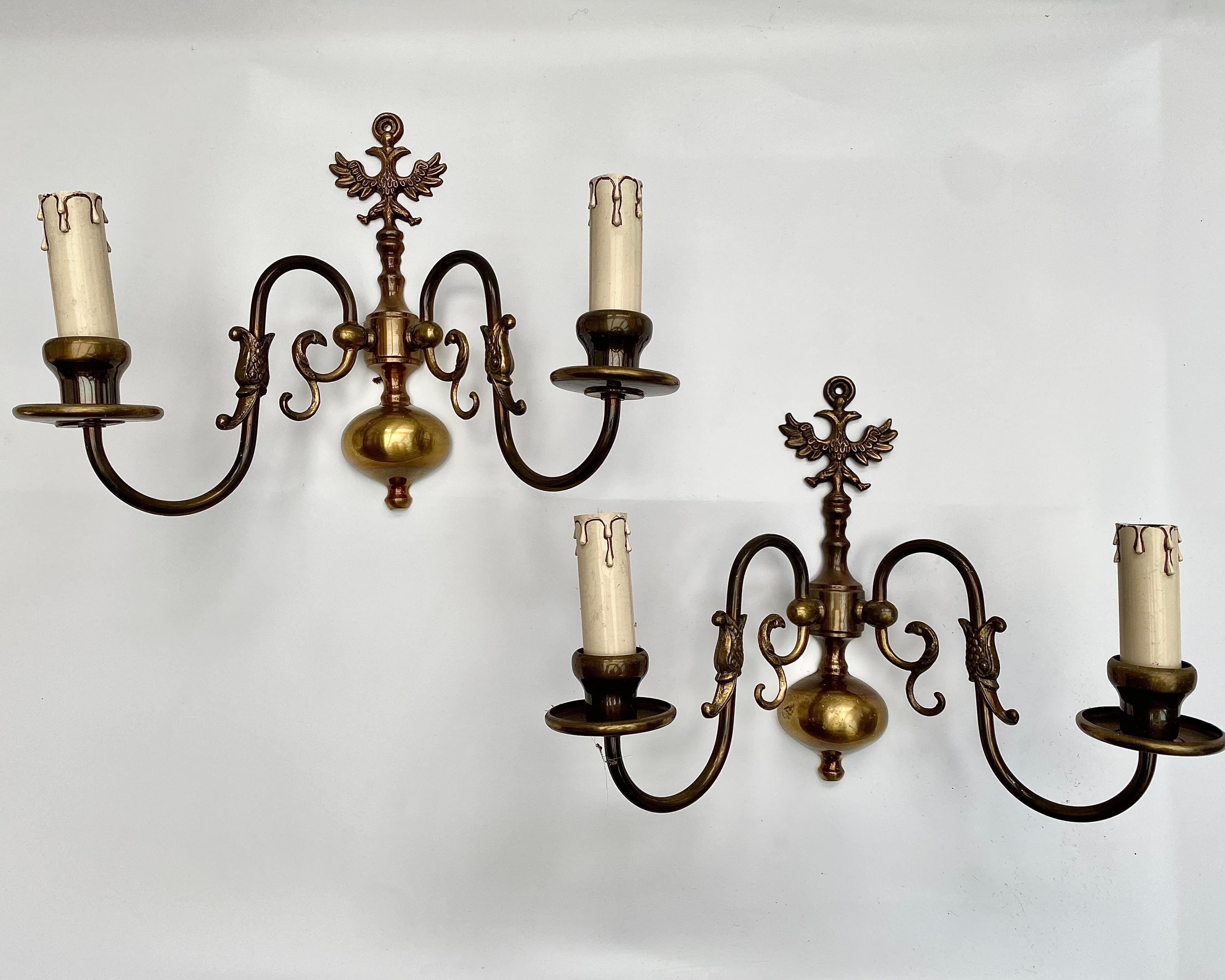 This striking pair of vintage brass sconces, from Belgium, 1970s, commands attention with their impressive size and unique double-headed eagle design. 

