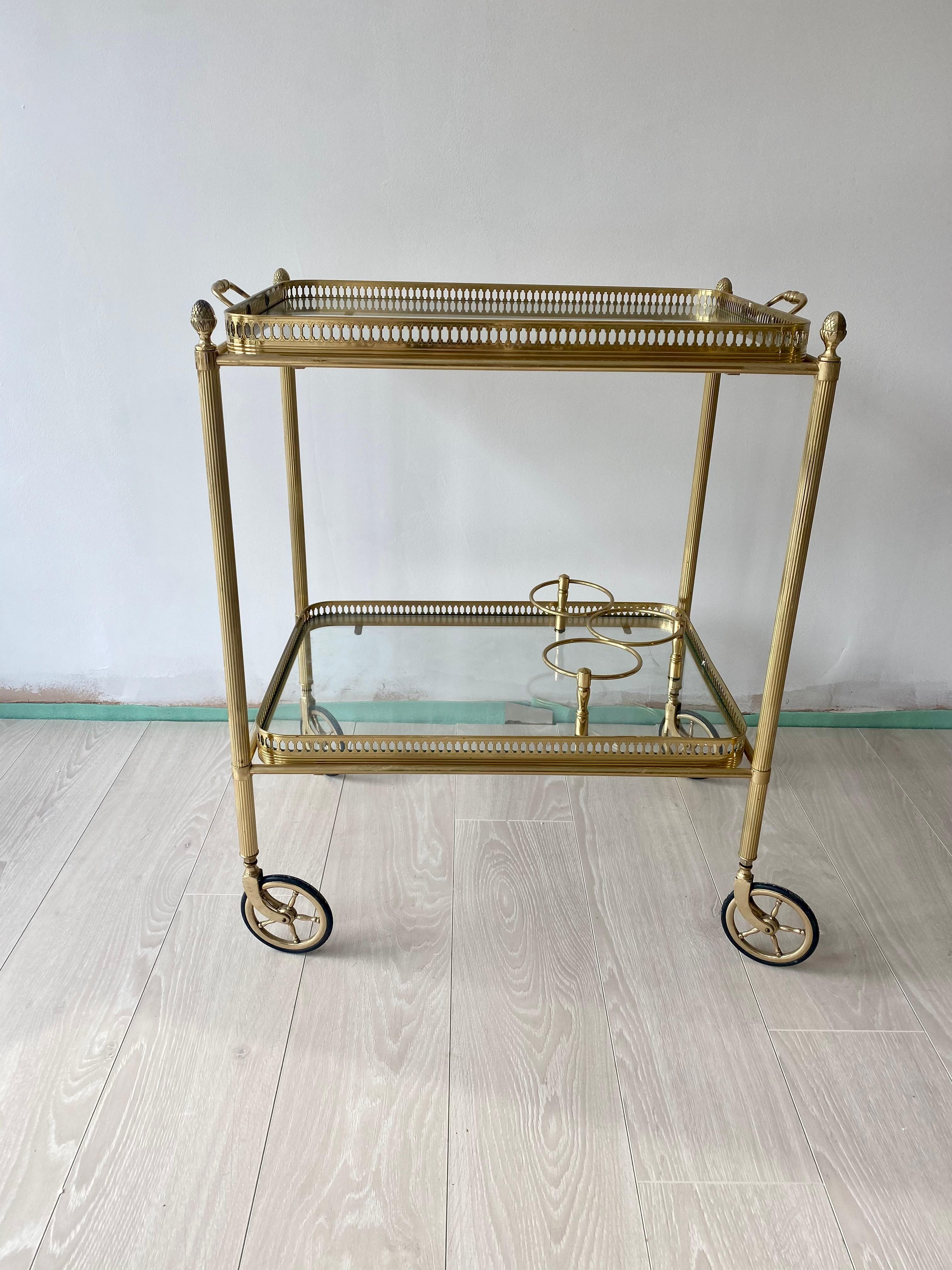 Perfect formed cocktail trolley from France 

Lift off top tray and bottle holder to lower tier

Brass frame with decorative finials

Top tray measures 50cm wide (58.5cm with handles)
40cm deep and stands 64cm to glass, 67.5cm to finials.