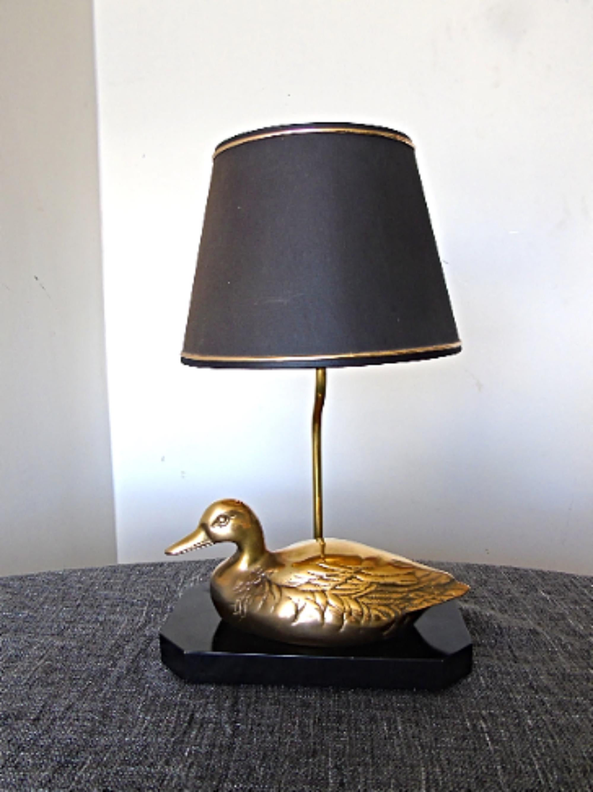 Beautiful Hollywood Regency brass duck table lamp.

The sculpture is mounted on a black lacquered wooden base.

Tested and ready to use with a regular E26/E27 light bulb.

France, 1970s. 

Dimensions:
Height 52cm/20.47