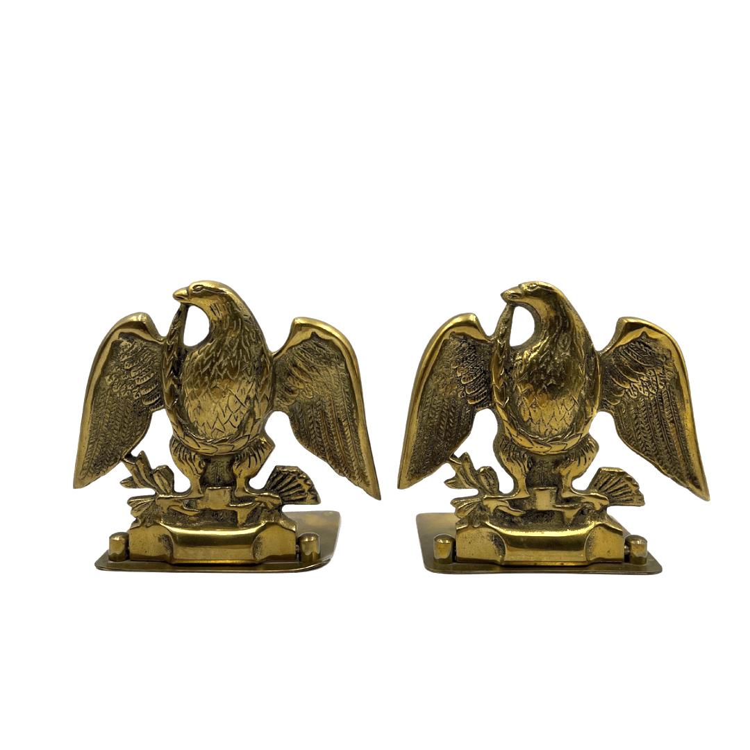 Offered is a set of vintage brass eagle bookends. Each bookend depicts a wingspread eagle clutching a bundle of arrows in its left talon and an olive branch in the right talon. When set against books, the base of the bookends slips underneath and