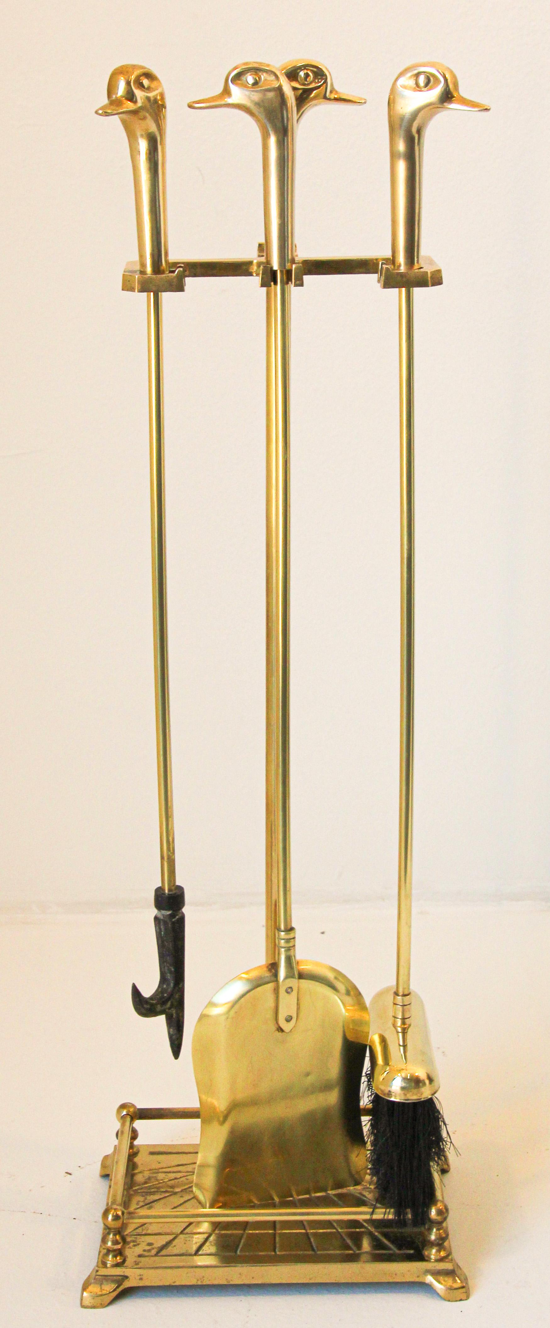 Vintage fireplace tools in brass with duck heads, French, circa 1960,
Five-pieces, fire tool set features a brass metal frame and three tools with duck head handles.
This set of brass fire-tools, includes broom, shovel and poker on elaborate stand