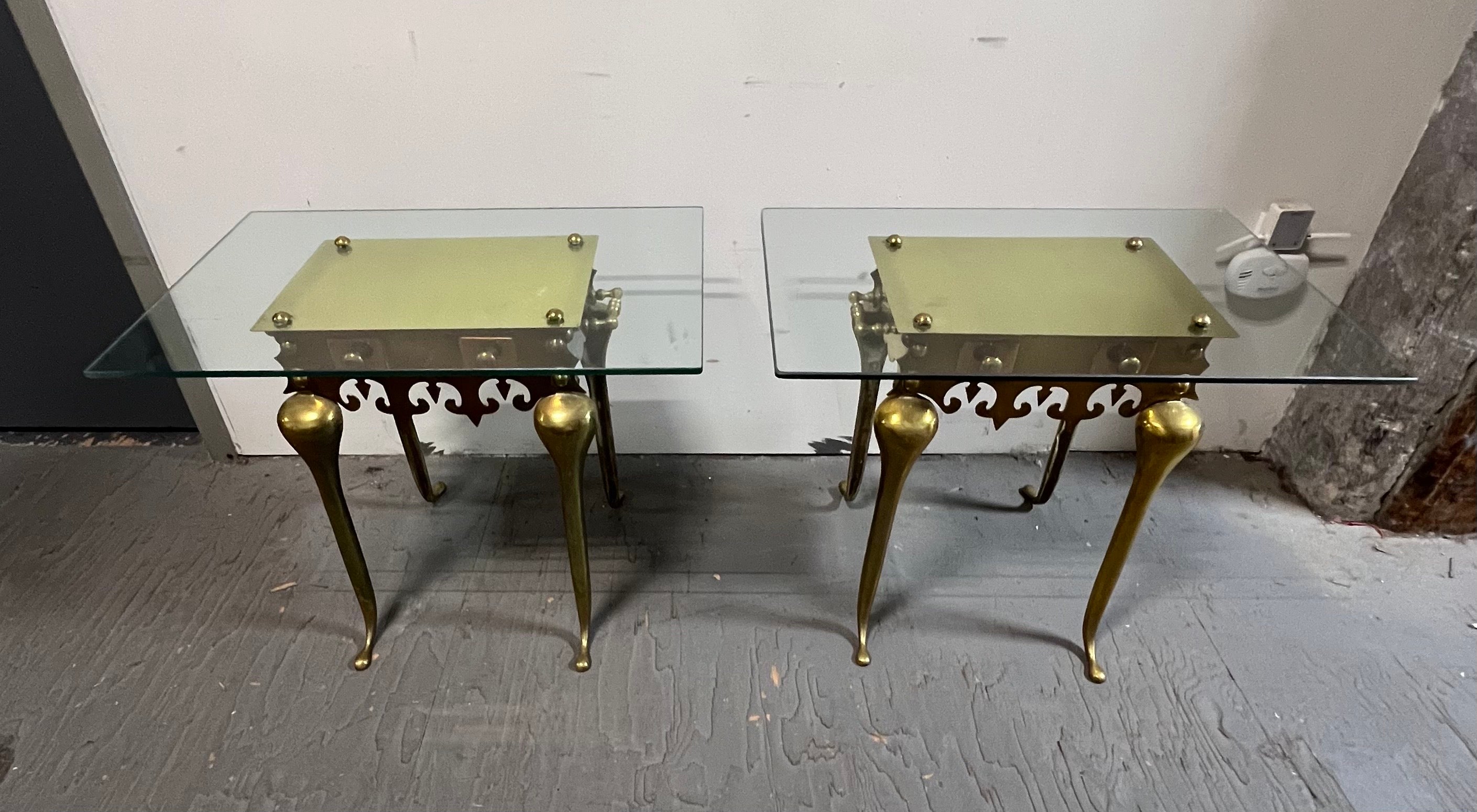 The footman was used to keep pots warm in the fireplace.

Pair of tall brass footman tables with shaped frieze and button knob fixtures. Handles on either side and gorgeous finials on all for corners. Custom glass tops which make them great side