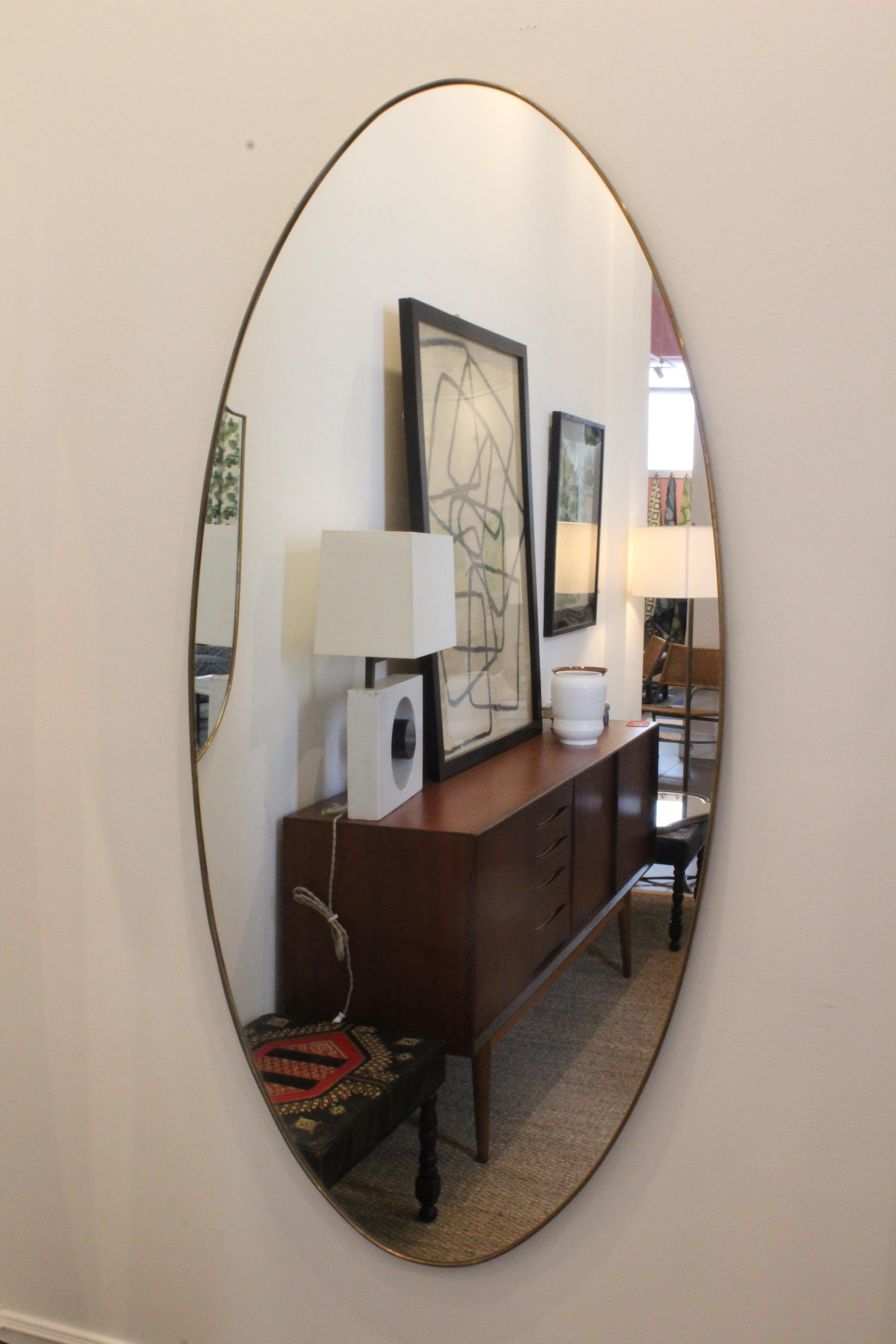 Vintage brass framed wall mirror. In good condition with age appropriate patina to the brass frame. Original mirror- may show minor signs of oxidation and patina.