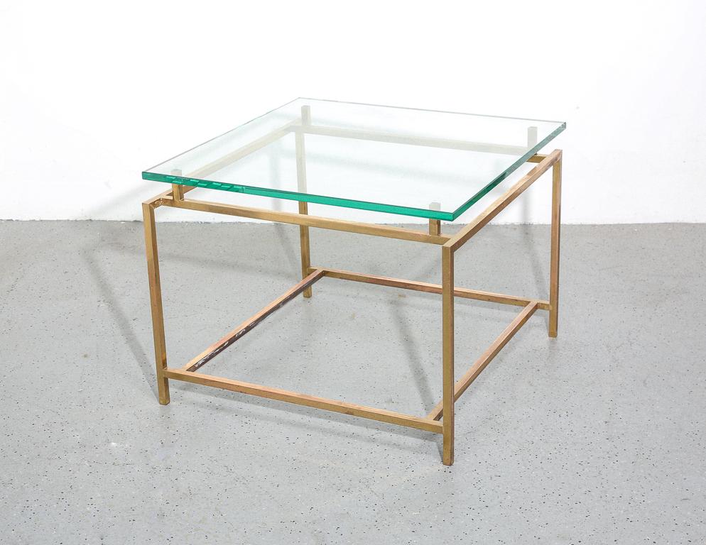 Vintage coffee table with architectural brass base and thick glass top. Attributed to Henning Norgaard.