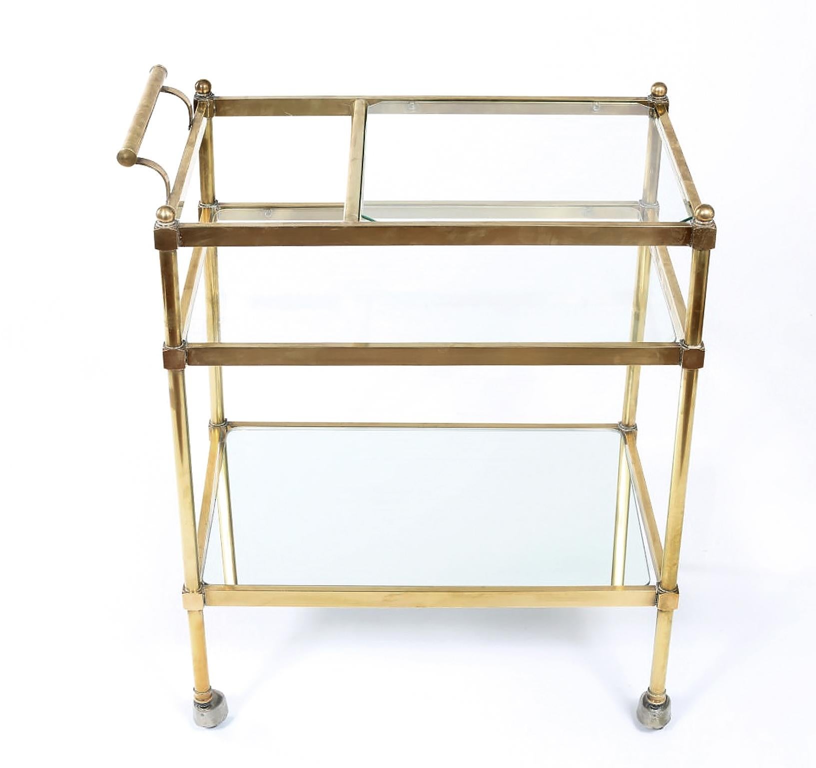 Stunning Italian three tiered brass/glass/mirror bar cart with space for bottles & side handle. The top two shelves are glass with the exception of the bottom shelve which is mirror shelve . The cart is in very good vintage condition with wear